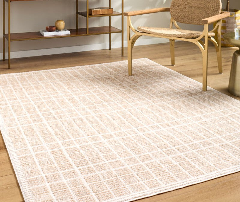 Elle Decor x Livabliss Beige Odeon rug with white grid pattern and textured weave, styled under a wooden chair in a minimalist living space.