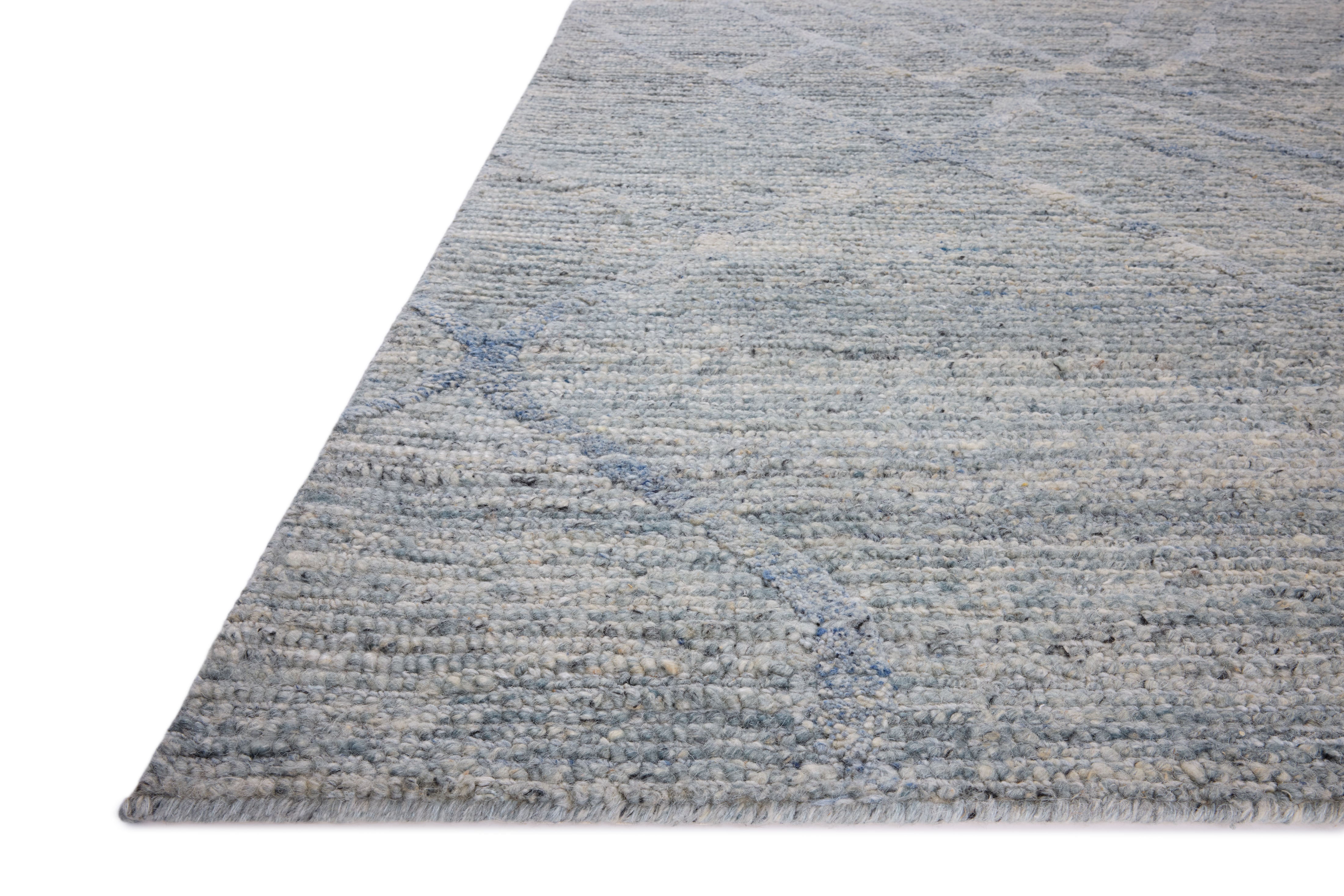The Cline CLI-01 Sky Area Rug blends breezy sky-blue tones into a hand-woven 100% wool area rug with timeless appeal