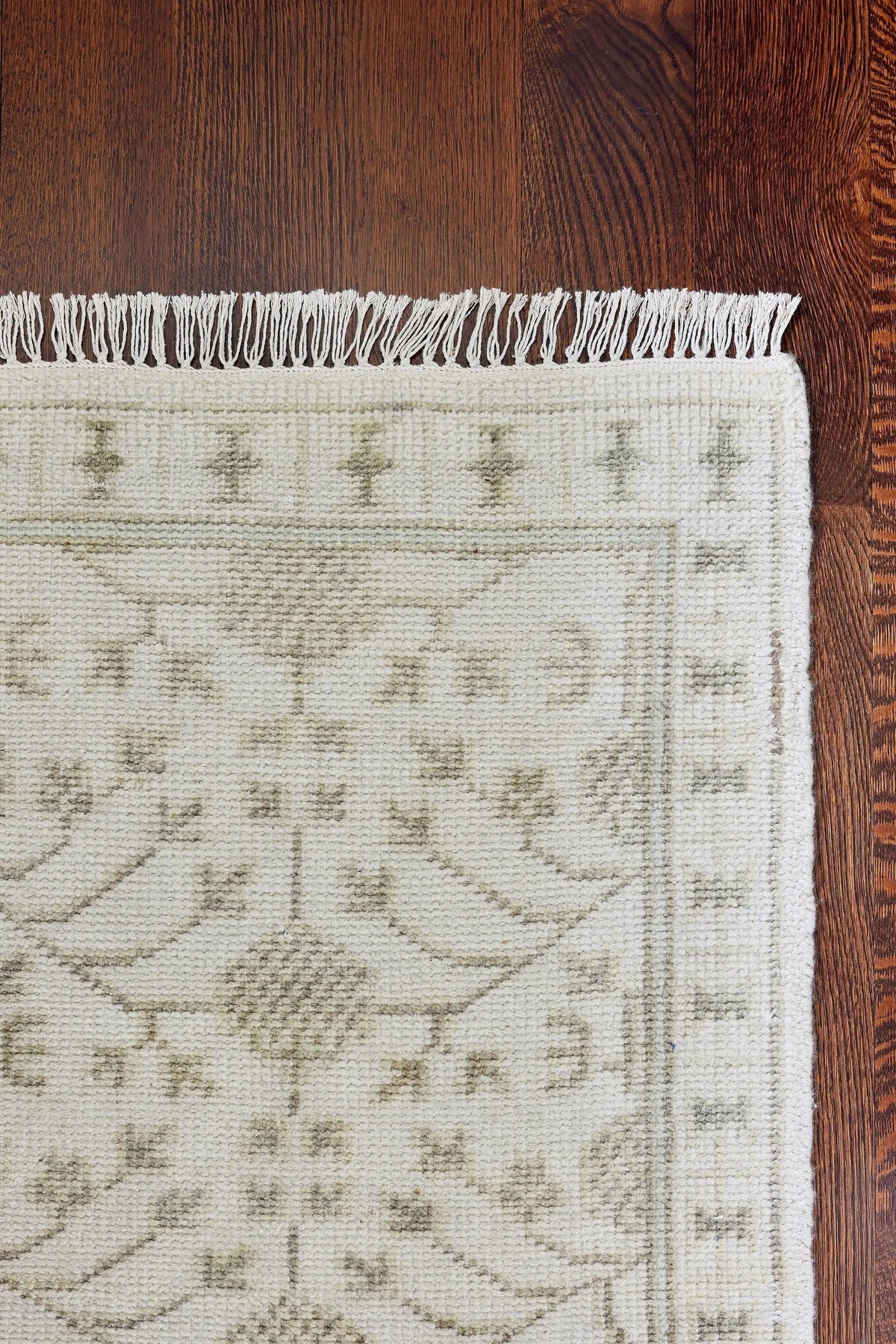 Erin Gates by Momeni Beige Concord CRD-2 Sudbury area rug featuring traditional canyon-inspired pattern, border detail, and woven fringe on dark wood floor.