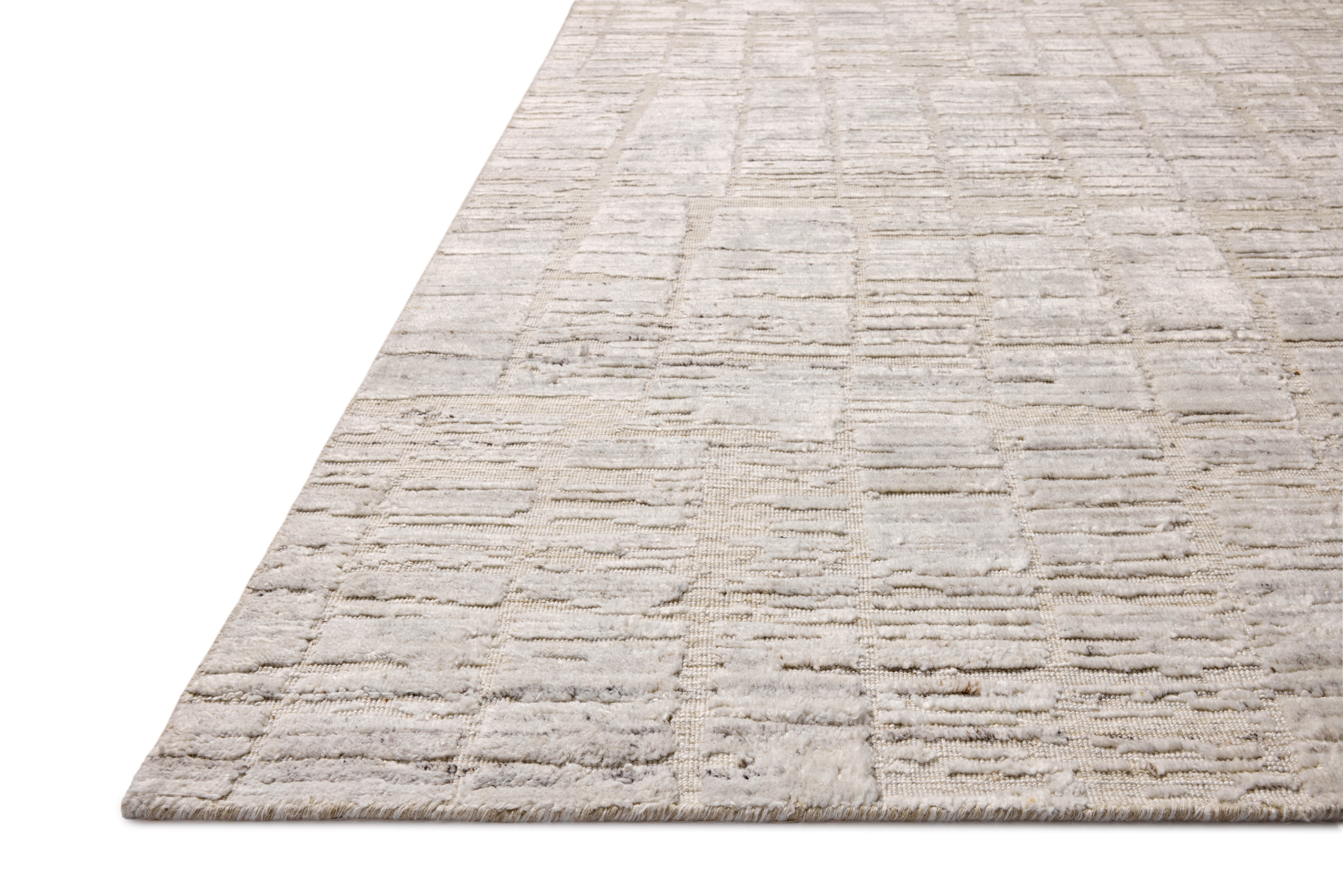Rich in antique ivory hues with ribbed and graphic detail, the Daniel DAN-01 Antique Ivory Area Rug is a hand-loomed bamboo and wool area rug built for style and comfort
