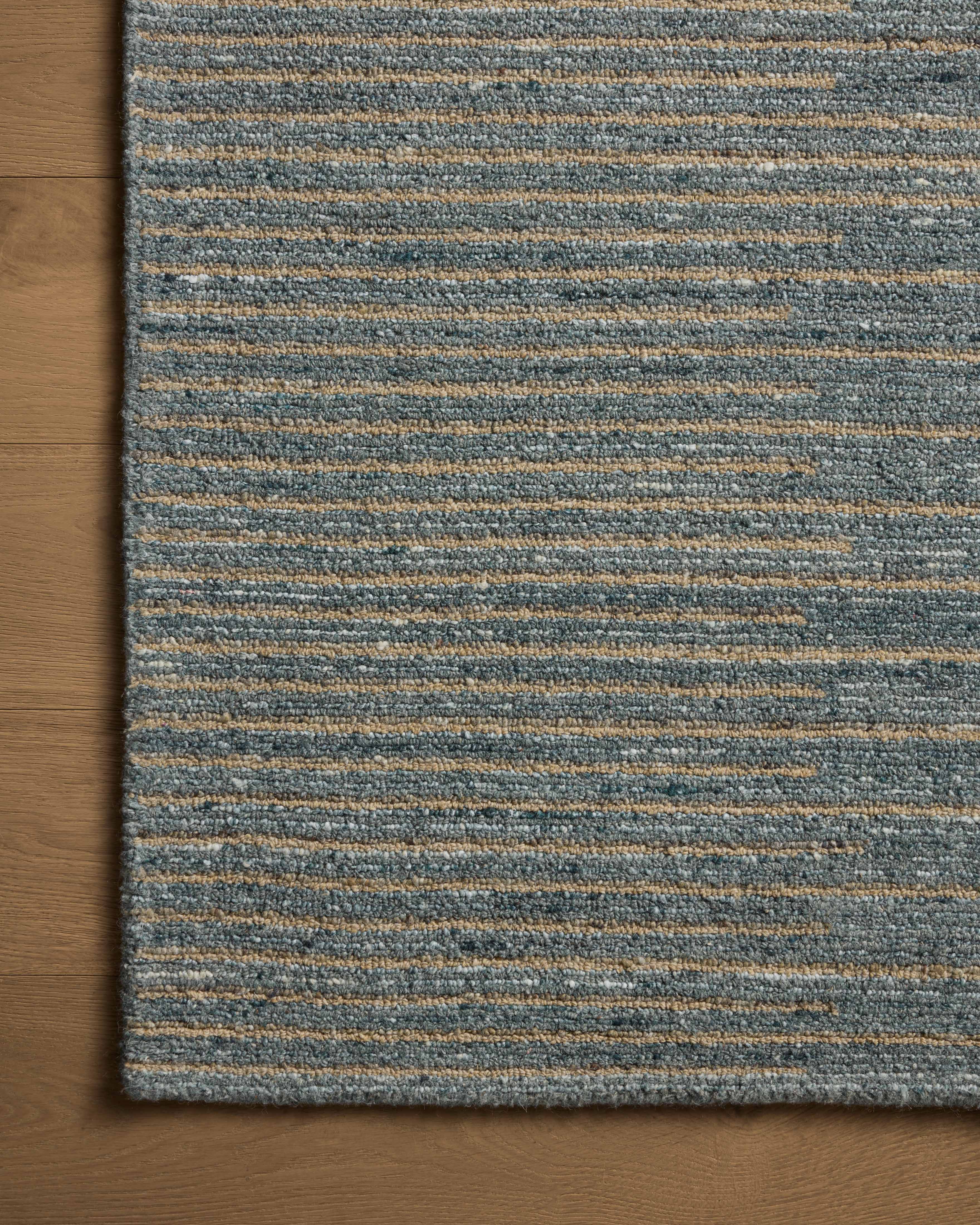 A hand-tufted wool area rug featuring graphic and high-low textured design and cool slate and warm natural tones, the Elias ELA-03 Slate / Natural Area Rug adds character to any room