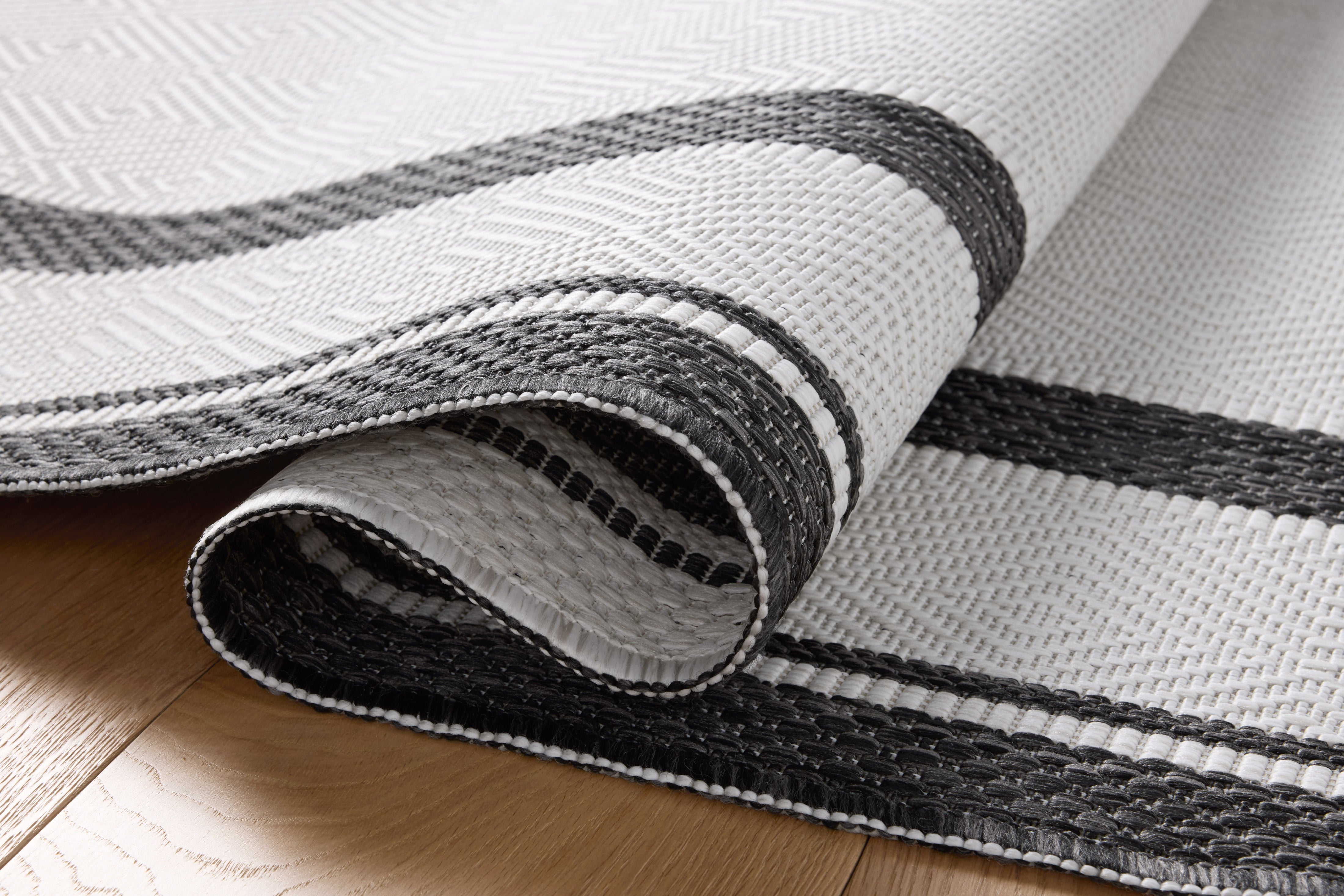 Finished in bold onyx and refined ivory tones, the Easton ESN-11 Onyx / Ivory Area Rug is a power-loomed polypropylene area rug for modern living