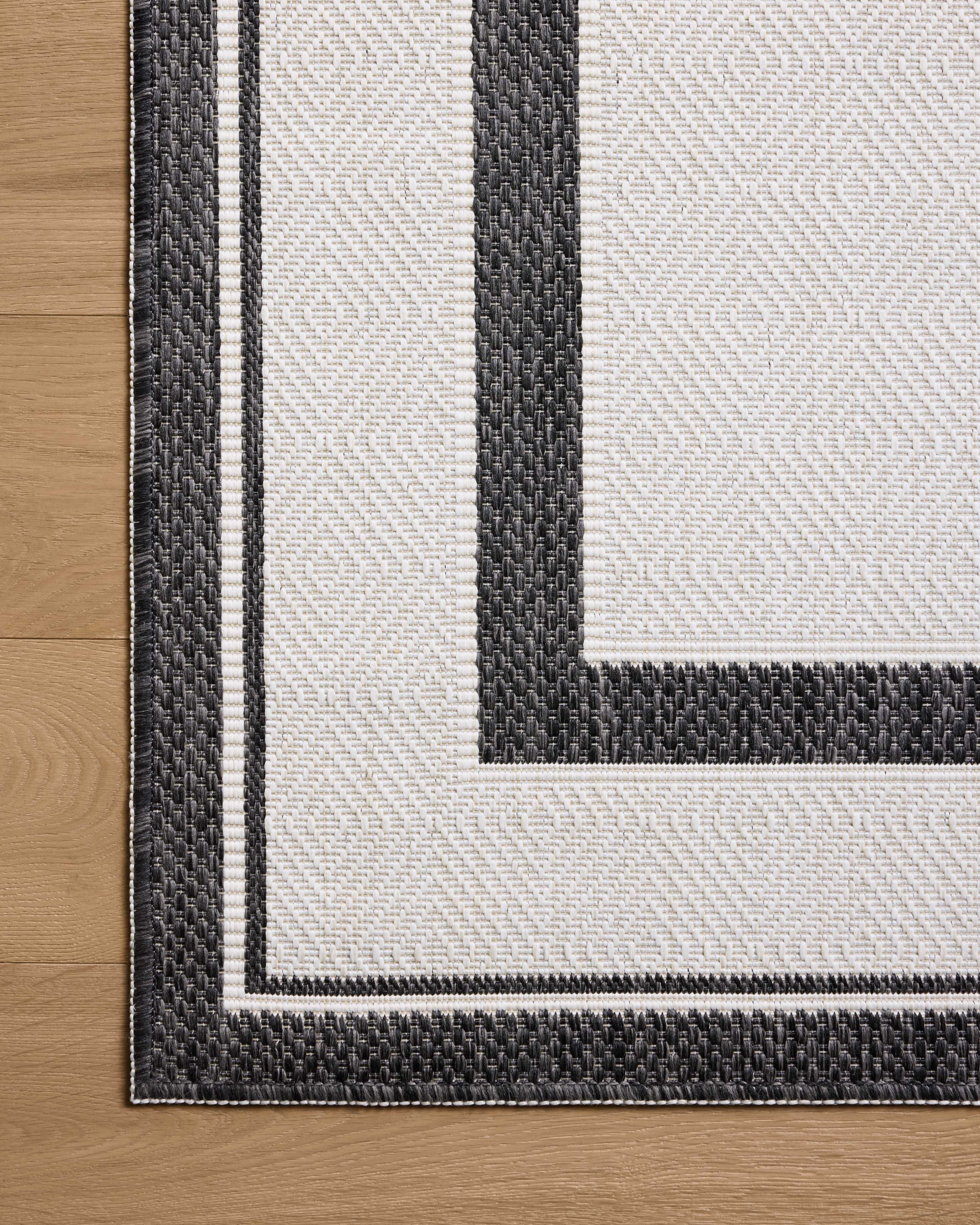 Finished in bold onyx and refined ivory tones, the Easton ESN-11 Onyx / Ivory Area Rug is a power-loomed polypropylene area rug for modern living