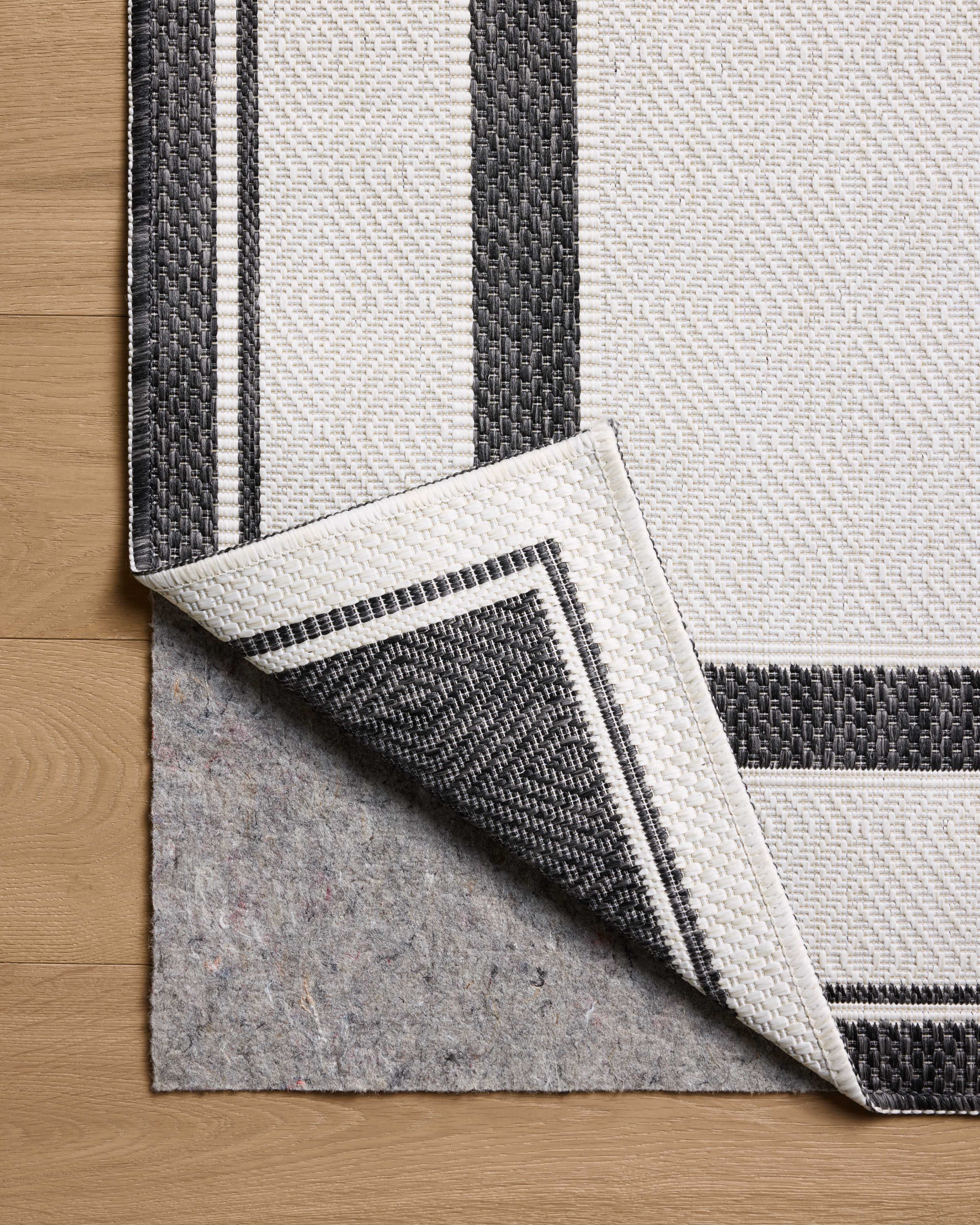 Finished in bold onyx and refined ivory tones, the Easton ESN-11 Onyx / Ivory Area Rug is a power-loomed polypropylene area rug for modern living