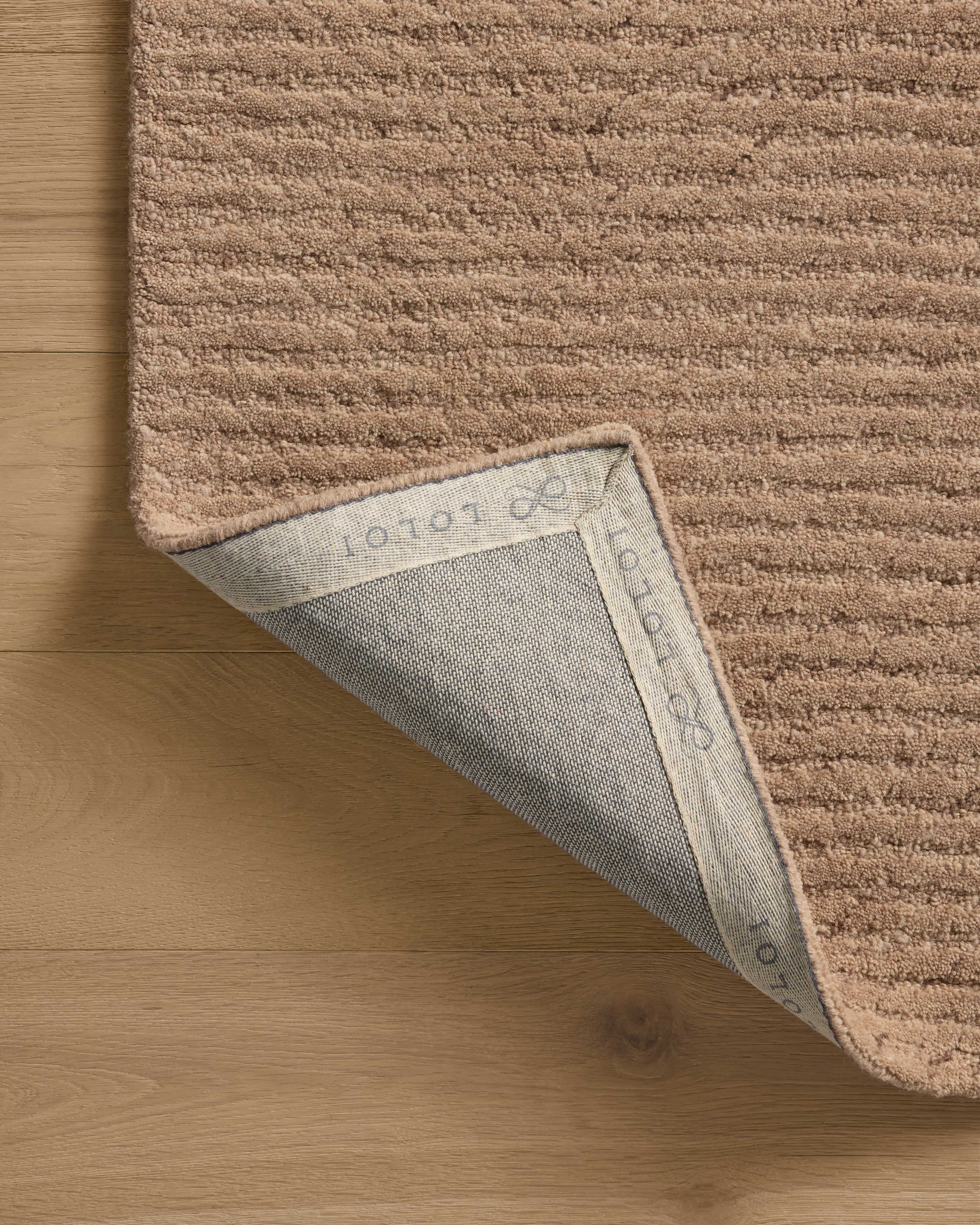 Finished in delicate blush tones with ribbed styling, the Kai KAI-01 Blush Area Rug is a hand-tufted wool area rug for modern living