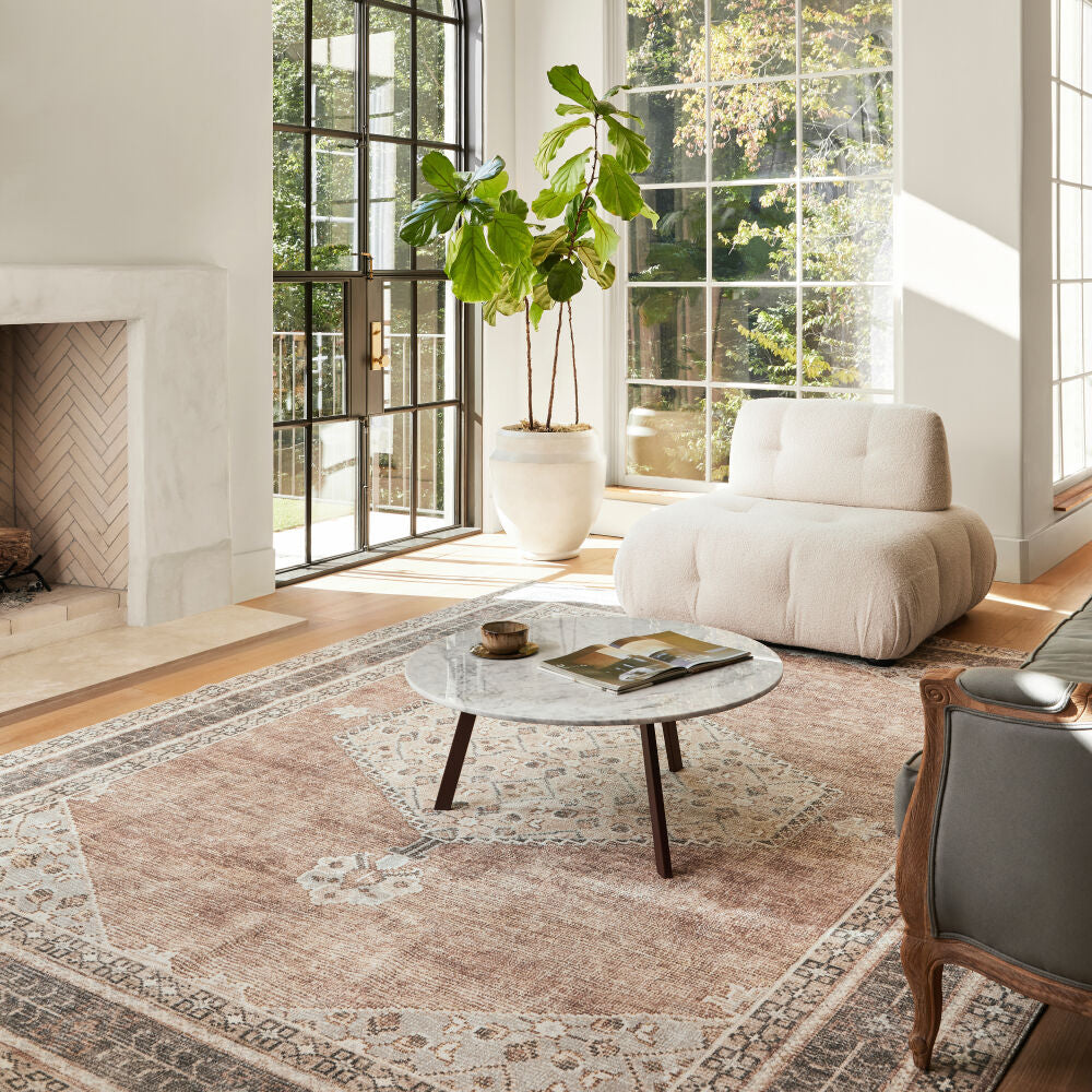 Becki Owens x Livabliss Lila BOLC-2300 machine-woven area rug in tan, displayed in a bright living room.