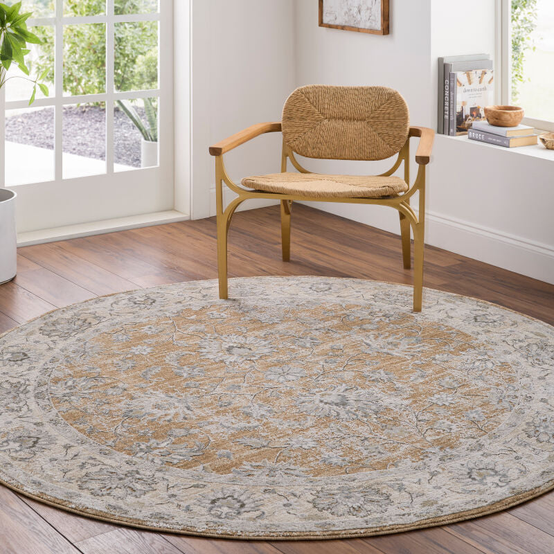 Round area rug featuring a vintage-inspired floral pattern in soft ivory, beige, gray, and muted gold, styled beneath a natural wood accent chair in a bright, modern interior. Discover elegant round rugs at Rug-Resources.com to add warmth and timeless charm to any room.