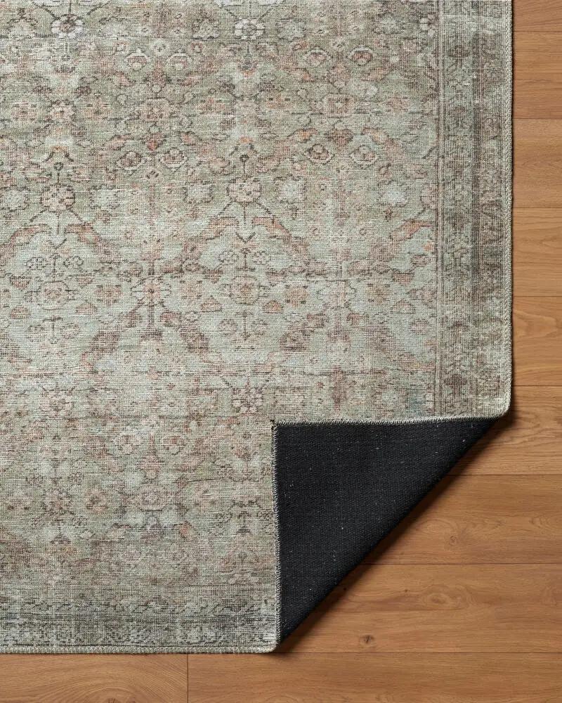 Close-up of the Amelia Blush Area Rug showing its faded vintage pattern and black non-slip backing.