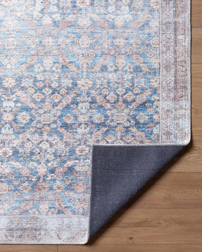 Close-up of the Amelia Slate Blue Area Rug showing its intricate pattern and dark non-slip backing.