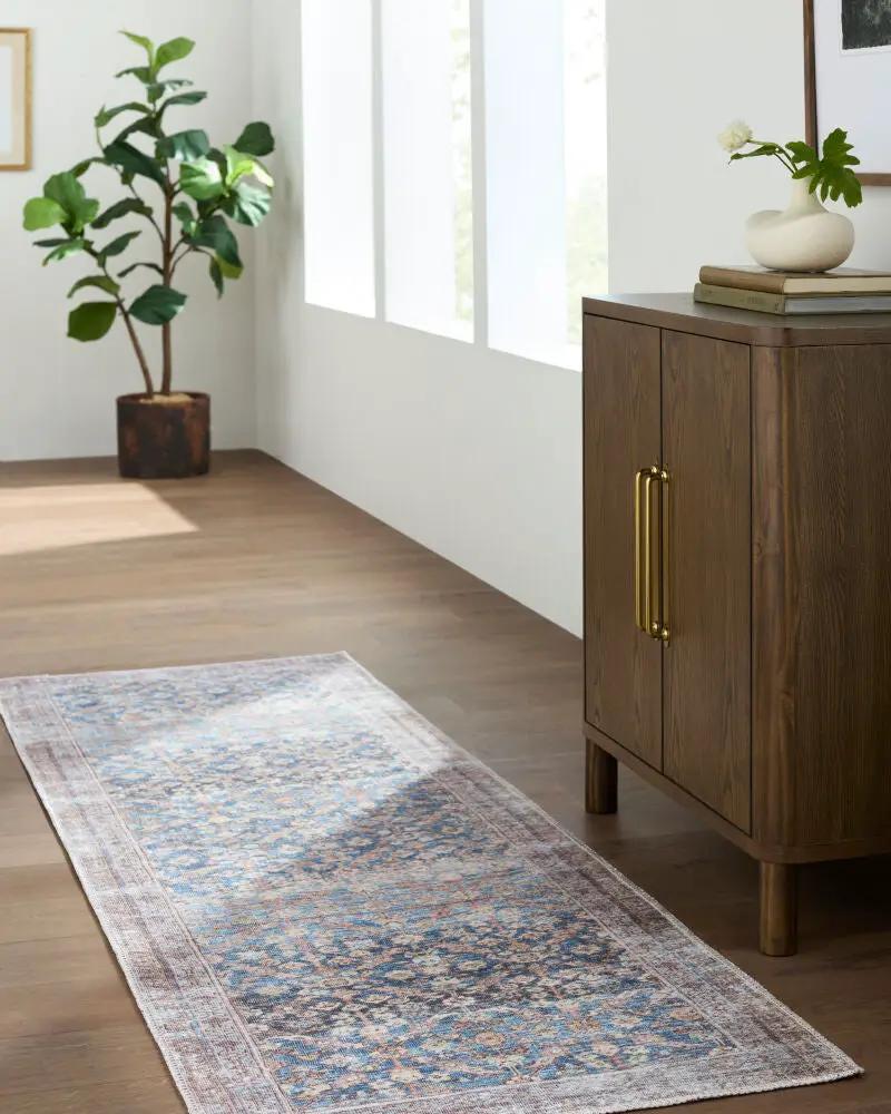 Amelia JYAL-2302 Slate Blue runner rug in a hallway next to a wooden cabinet and potted plant.