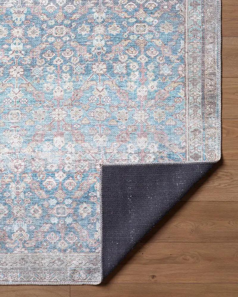 Close-up of the Amelia Sky Blue Area Rug showing its intricate pattern and dark non-slip backing.