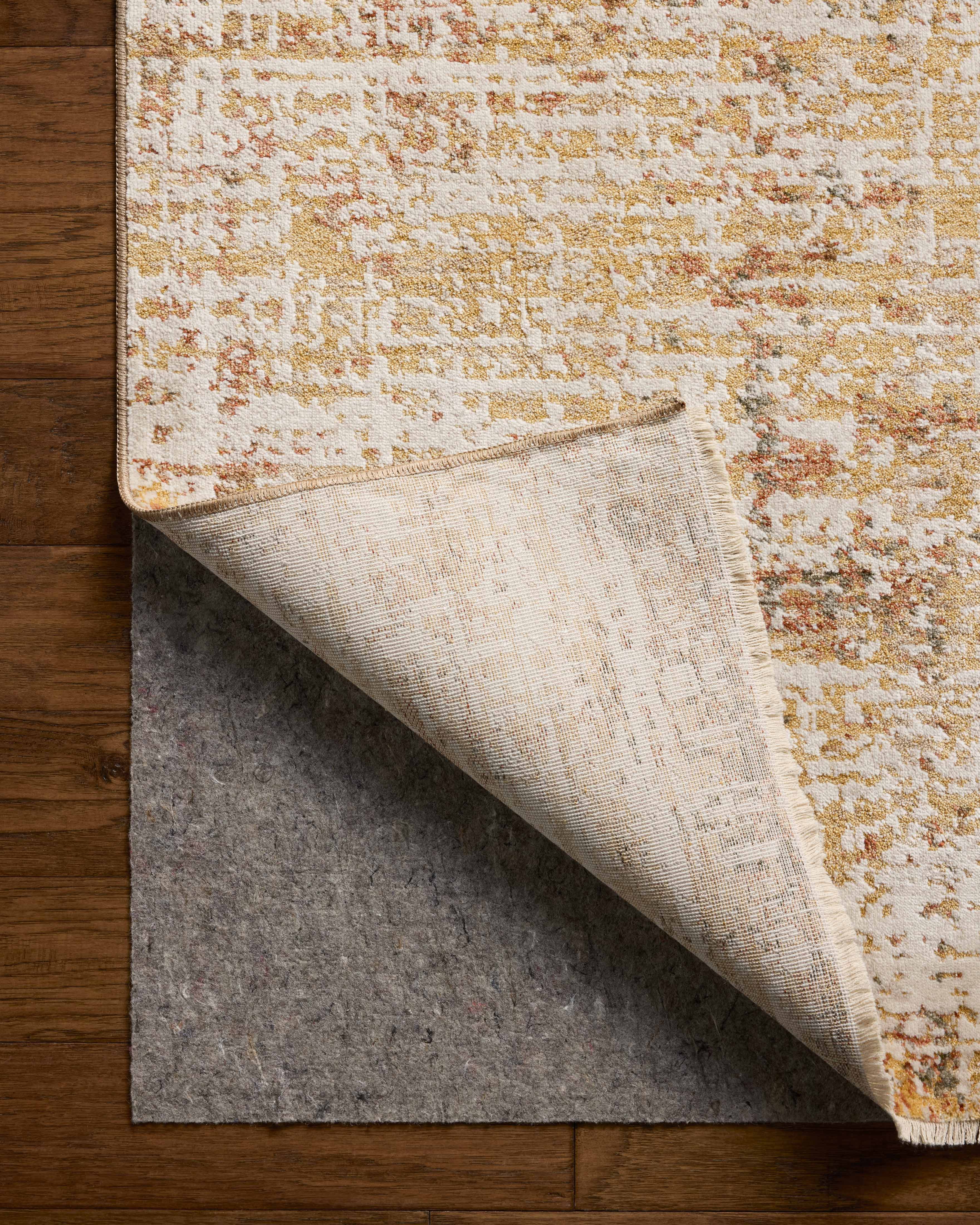The Nellie NEL-02 Sunset / Pebble Area Rug pairs glowing sunset and subtle pebble tones and graphic patterns in a power-loomed polyester and polypropylene area rug