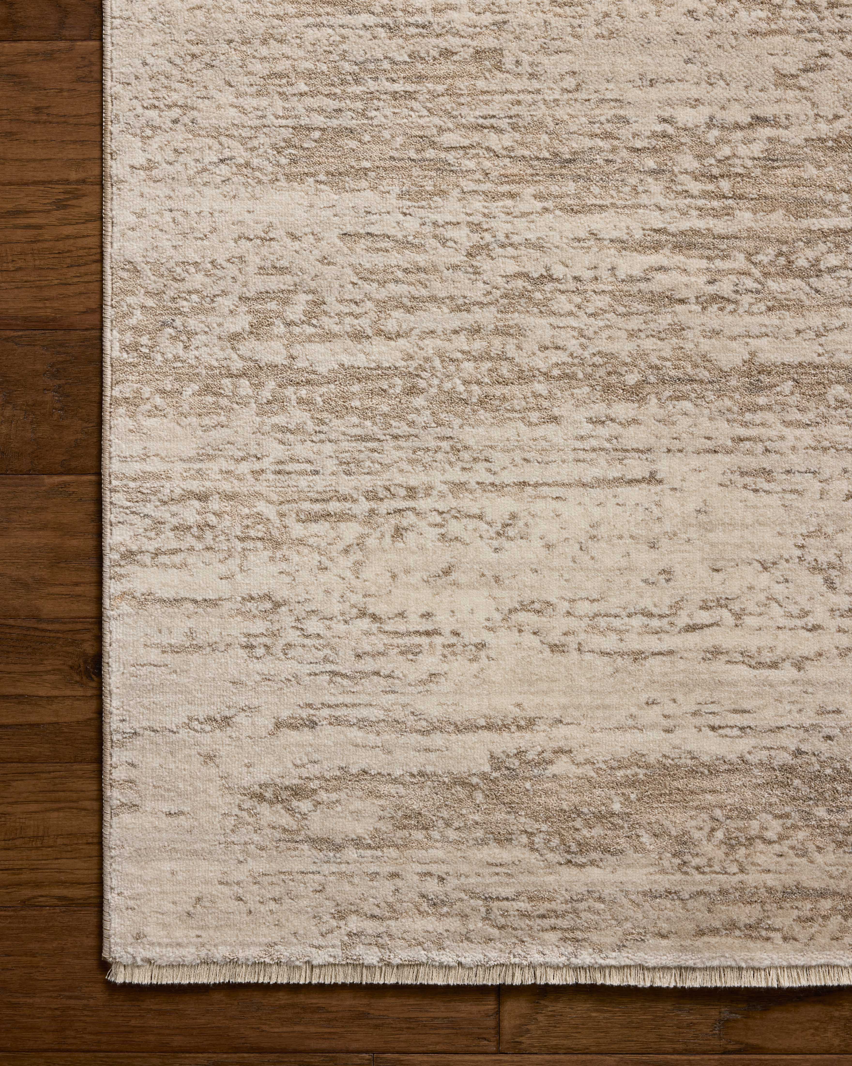 The Nellie NEL-04 Ivory / Pebble Area Rug blends refined ivory and subtle pebble tones and graphic motifs into a power-loomed polyester and polypropylene area rug with timeless appeal