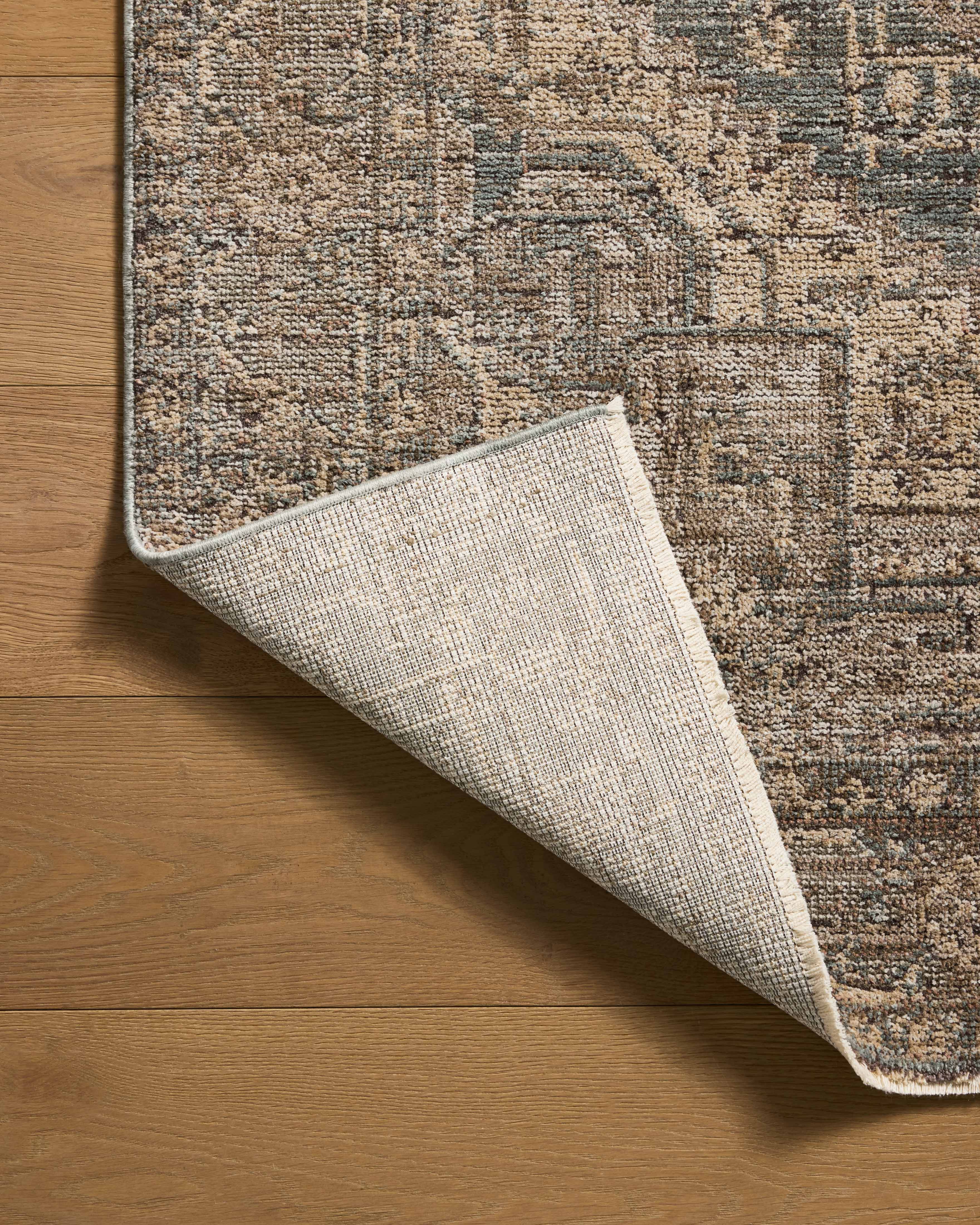 A power-loomed 100% polyester area rug with vintage flair in calming blue and grounded bark tones, the Priscilla PRL-04 Blue / Bark Area Rug anchors any room