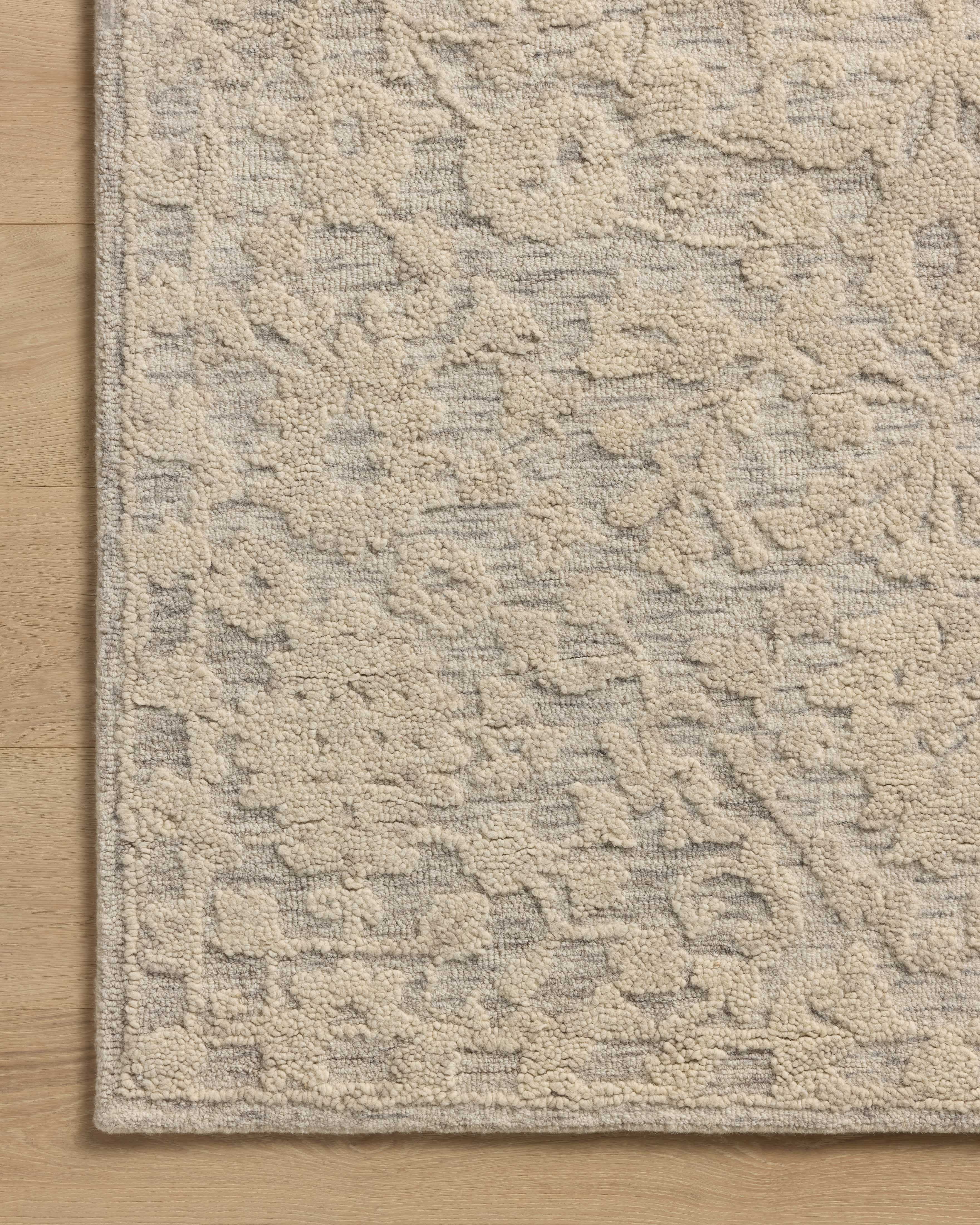 A hand-tufted wool and cotton area rug with floral flair in soft misty and refined ivory tones, the Prudence PRU-01 Mist / Ivory Area Rug anchors any room