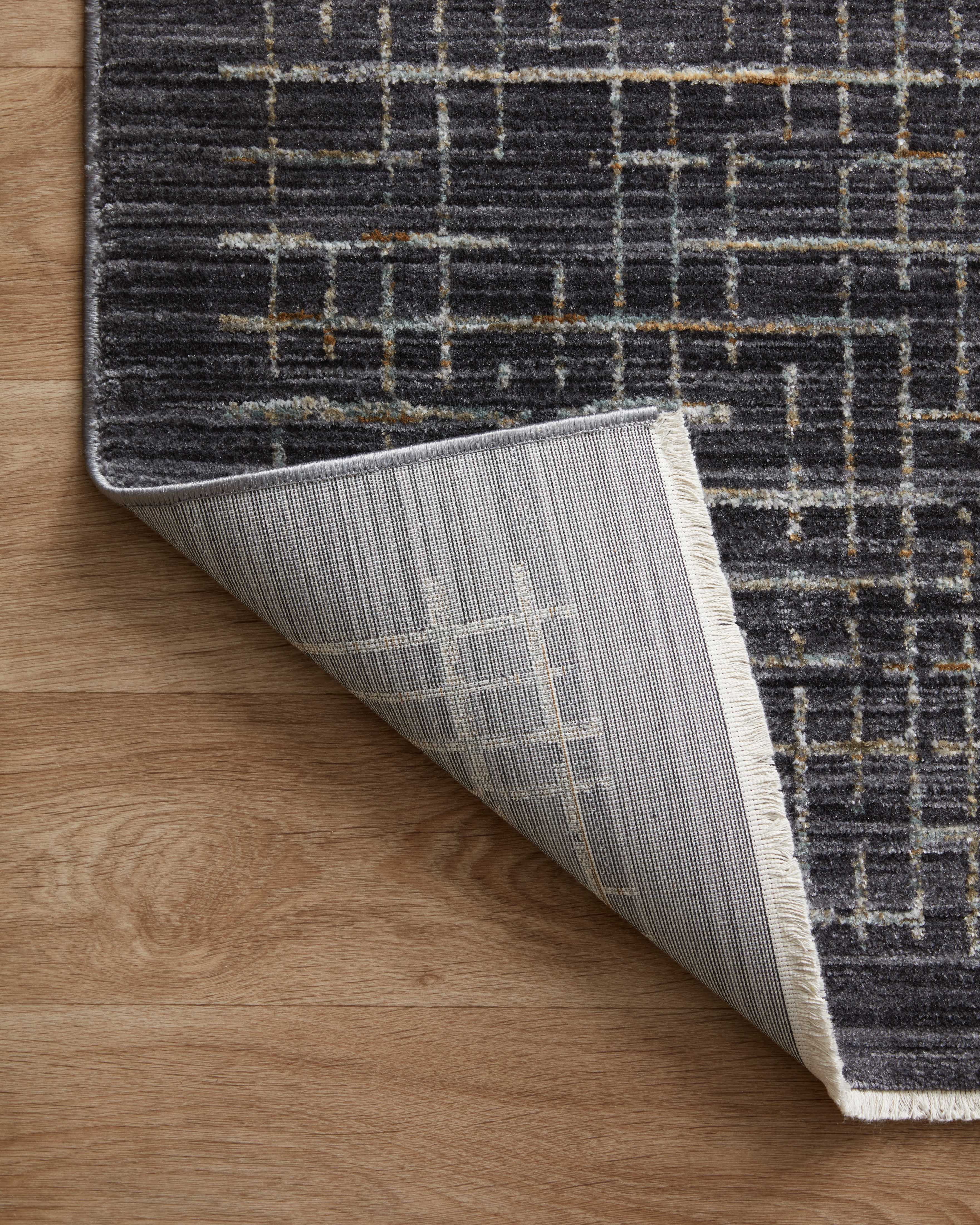 With bold onyx and shimmering silver hues and contemporary and abstract styling, the Soho SOH-01 Onyx / Silver Area Rug is a power-loomed 100% polyester area rug that elevates any room