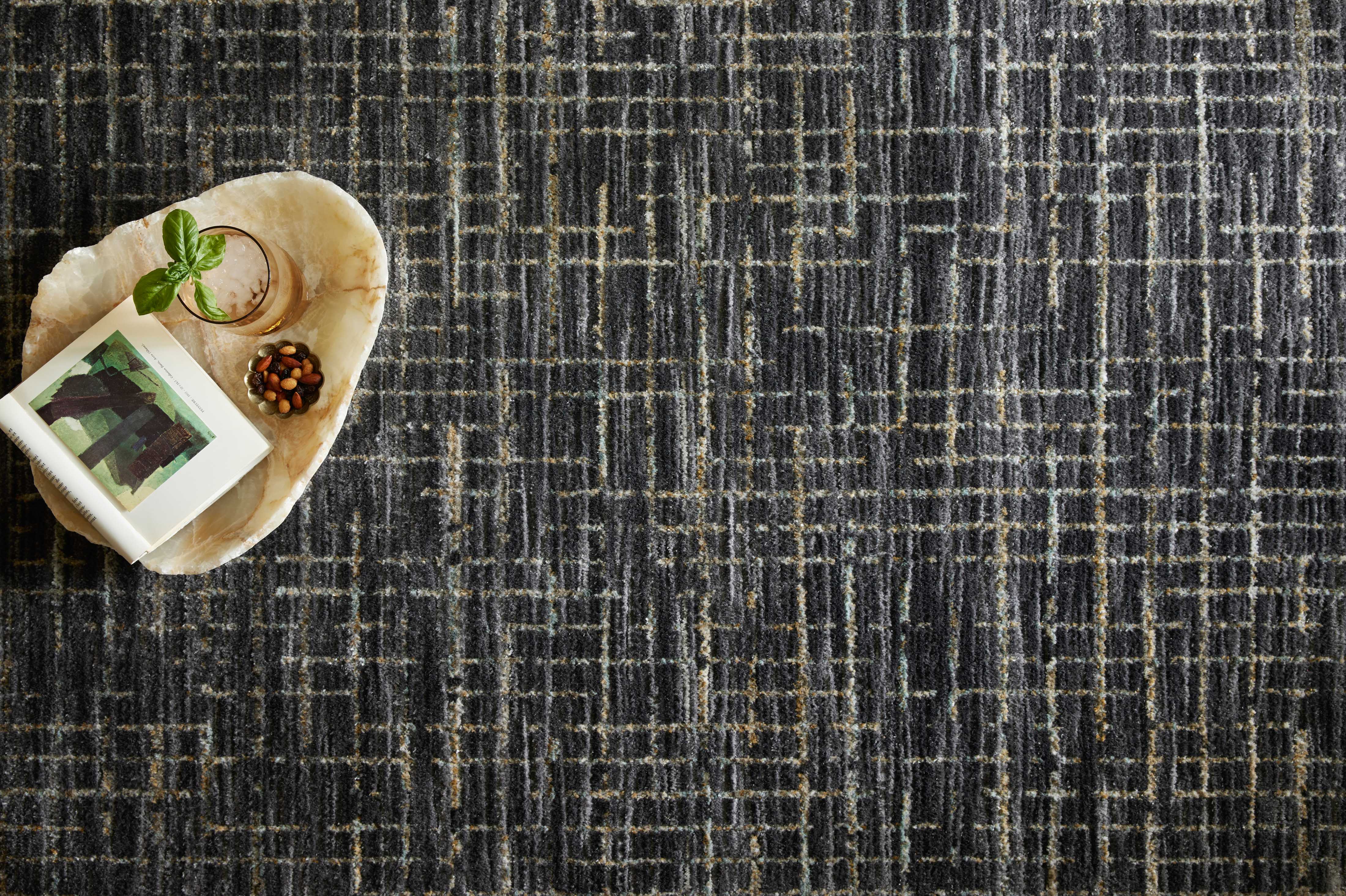 With bold onyx and shimmering silver hues and contemporary and abstract styling, the Soho SOH-01 Onyx / Silver Area Rug is a power-loomed 100% polyester area rug that elevates any room