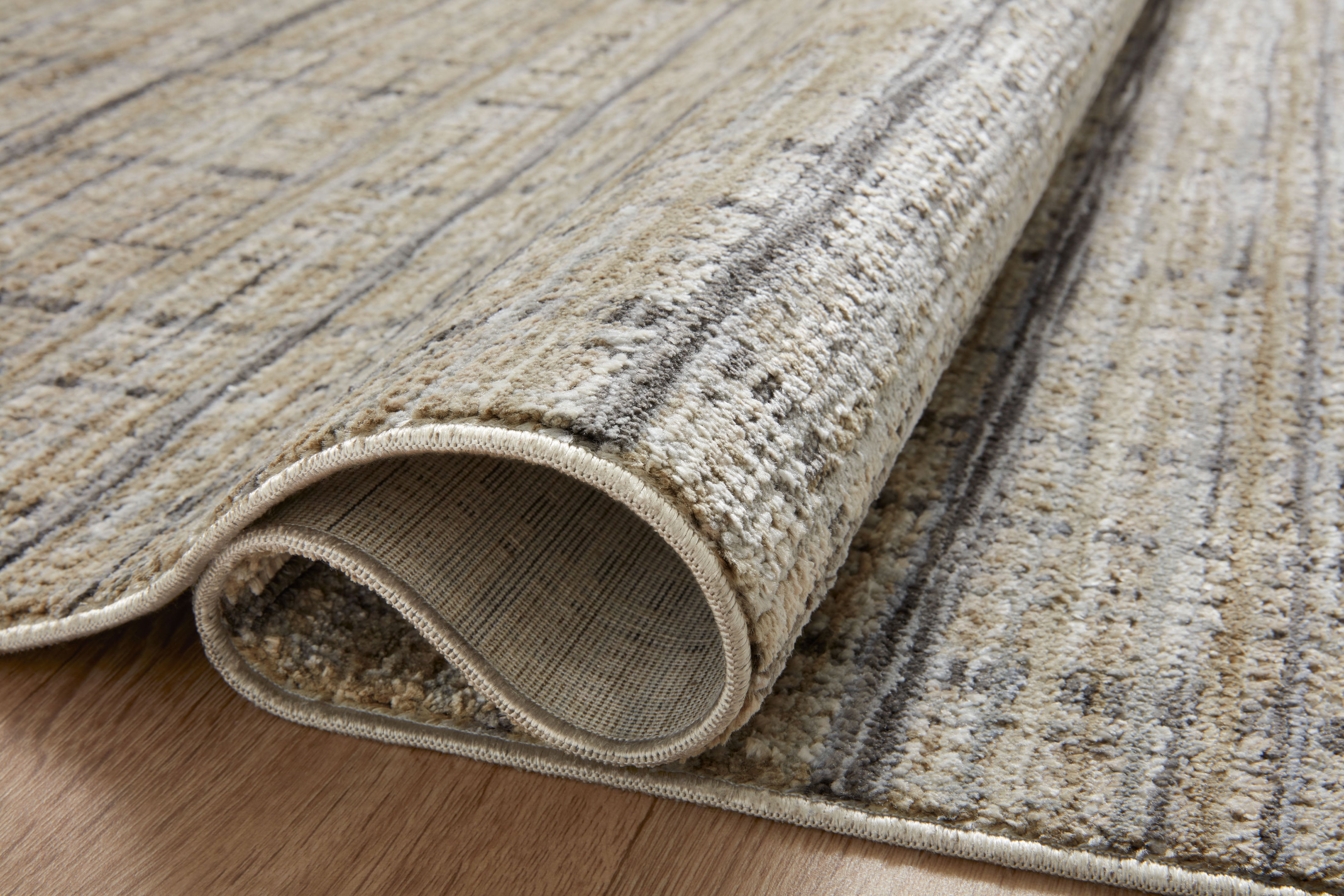 Designed with contemporary and abstract artistry in subtle pebble and deep charcoal hues, the Soho SOH-04 Pebble / Charcoal Area Rug is a power-loomed 100% polyester area rug that stands out