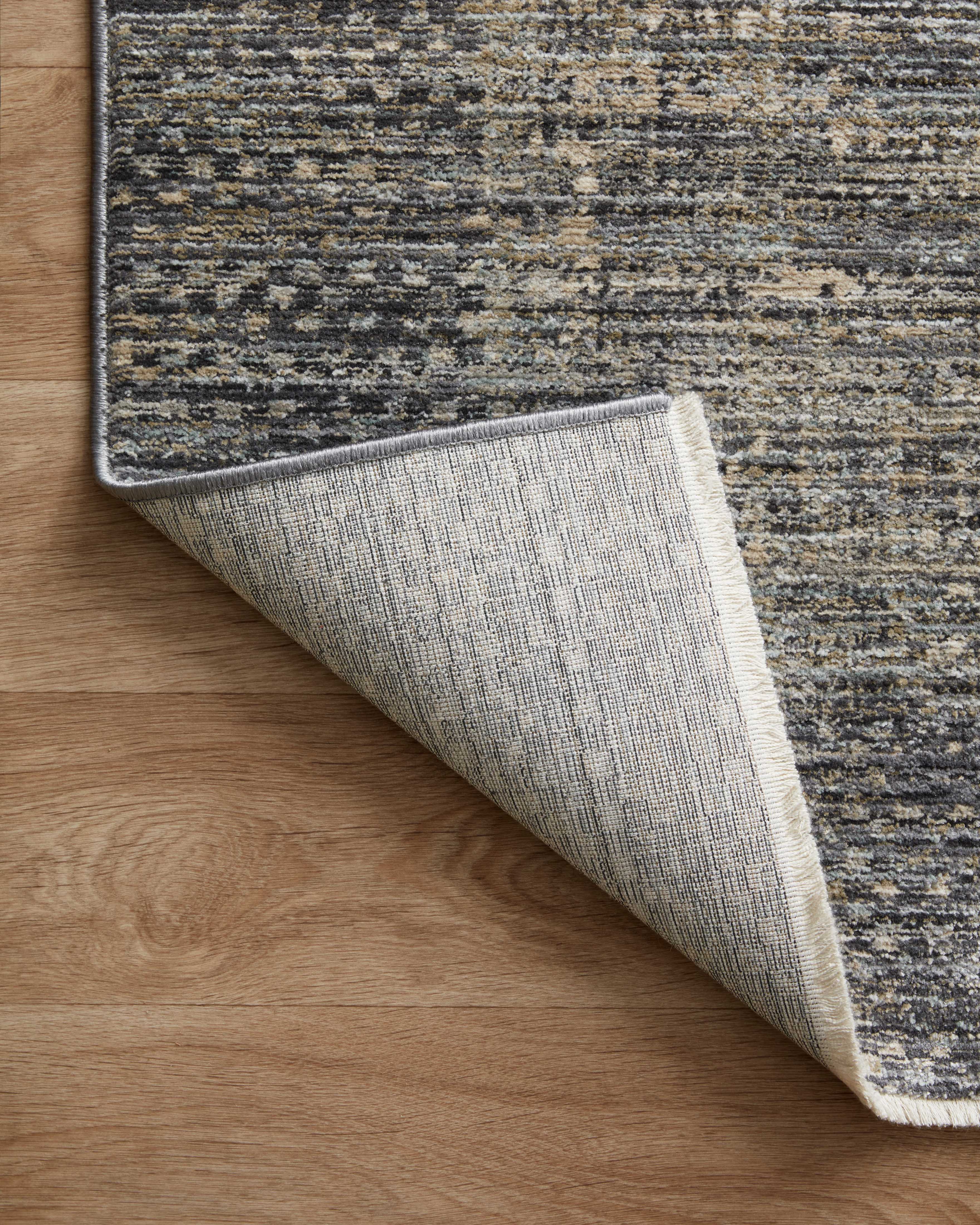 A power-loomed 100% polyester area rug featuring contemporary and abstract design and vibrant multi-toned and cool slate tones, the Soho SOH-06 Multi / Slate Area Rug adds character to any room