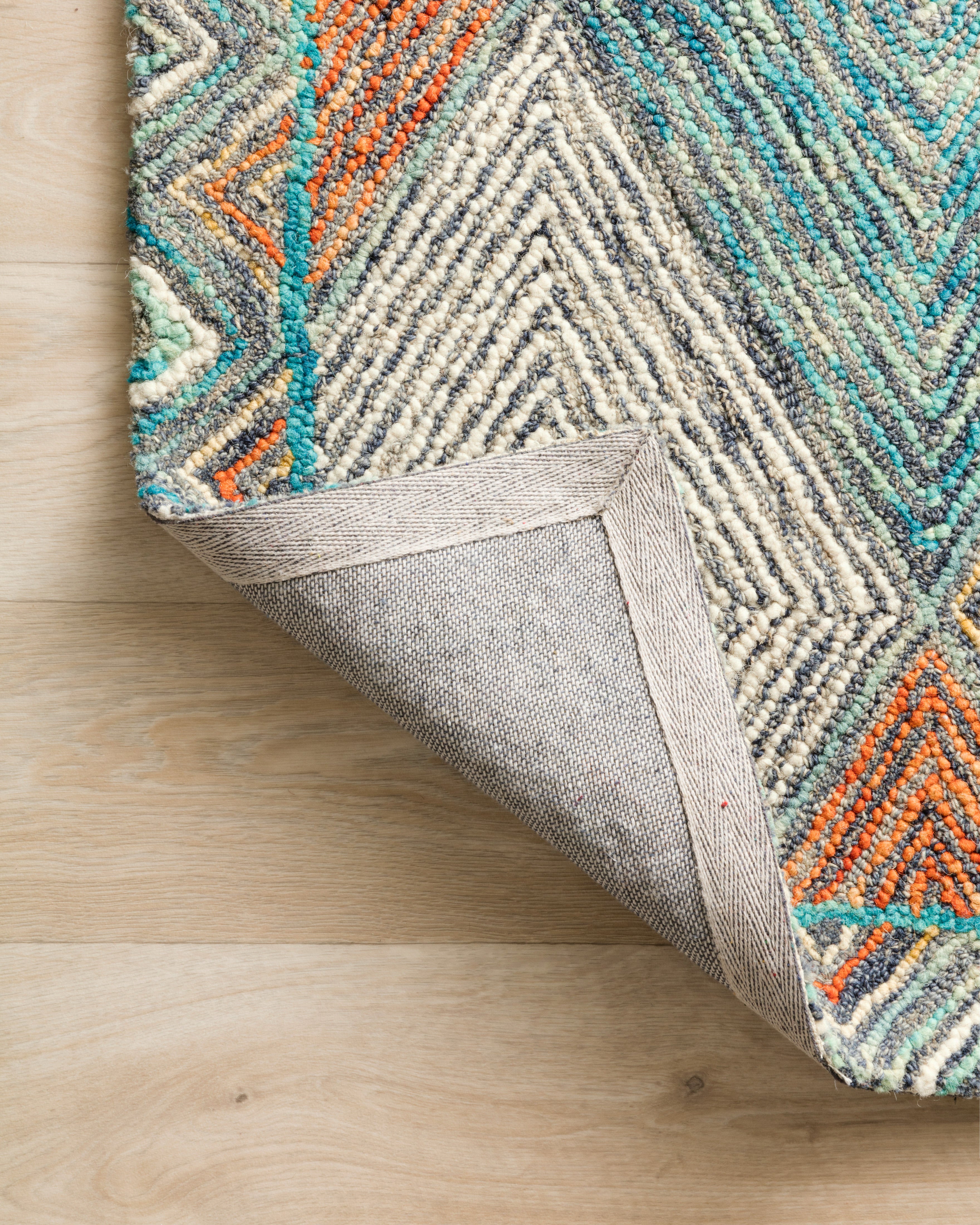 The Spectrum SPE-02 Sunset / Ocean Area Rug offers glowing sunset and serene ocean sophistication and geometric and eclectic charm in a hooked wool area rug