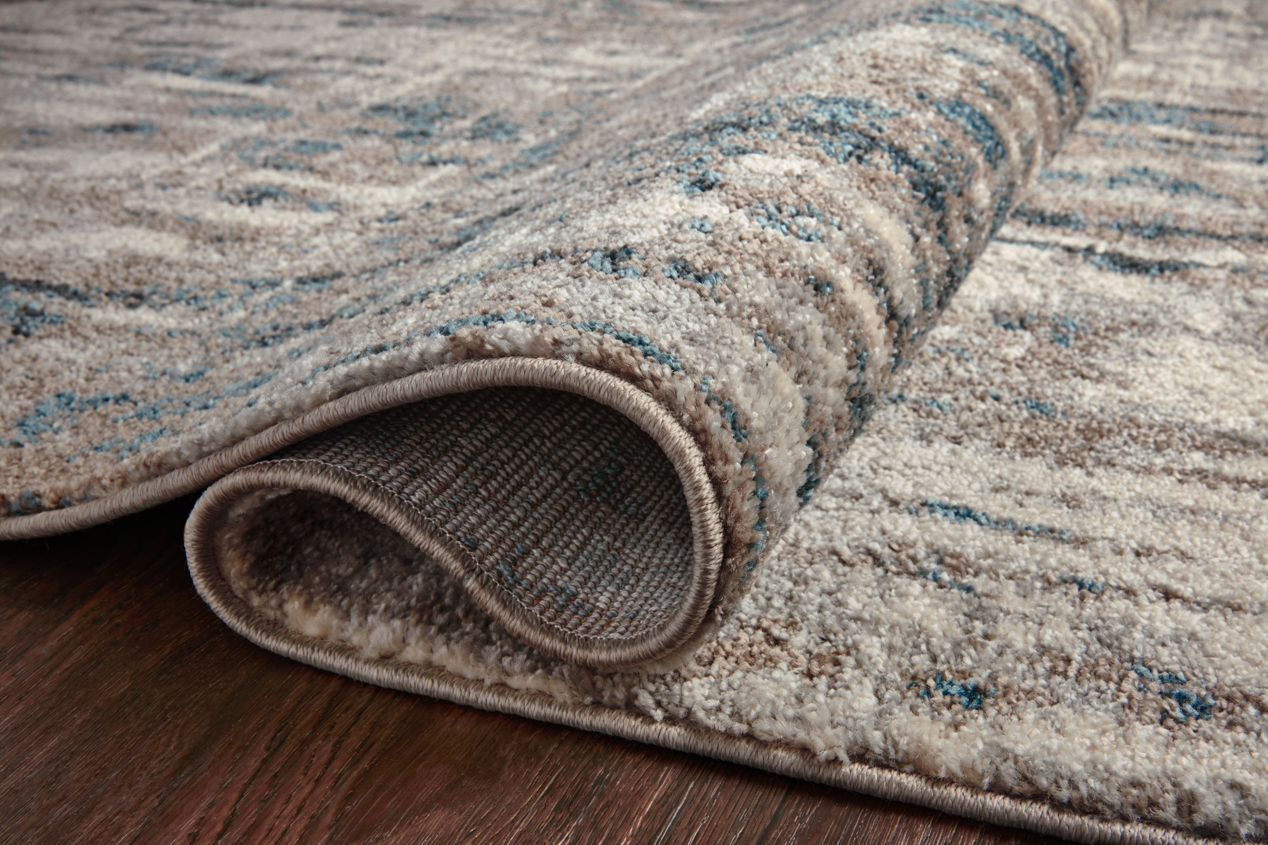 A power-loomed 100% polypropylene area rug with abstract design in grounding stone and calming blue hues, the Spirit SPI-02 Stone / Blue Area Rug is a standout in any décor