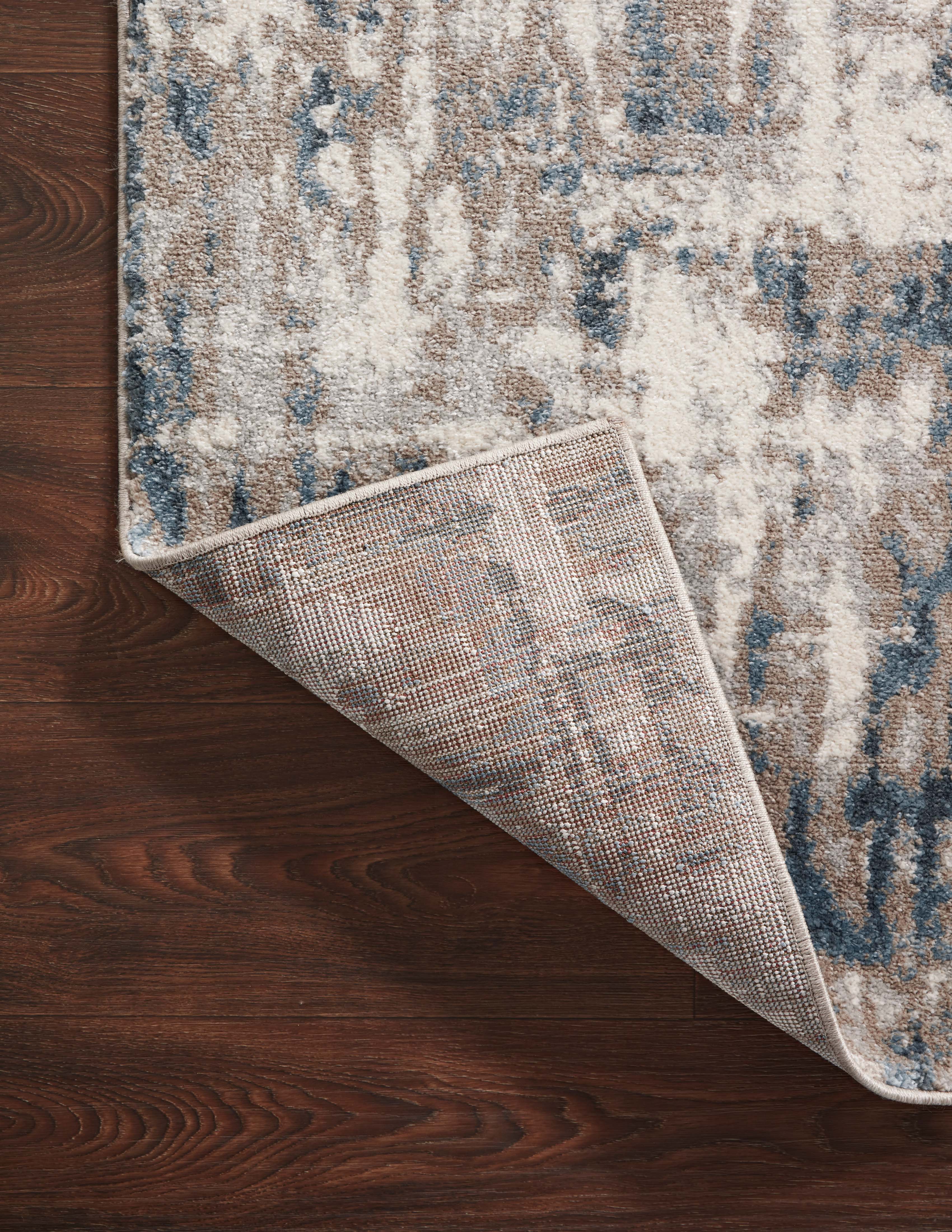 A power-loomed 100% polypropylene area rug with abstract design in grounding stone and calming blue hues, the Spirit SPI-02 Stone / Blue Area Rug is a standout in any décor