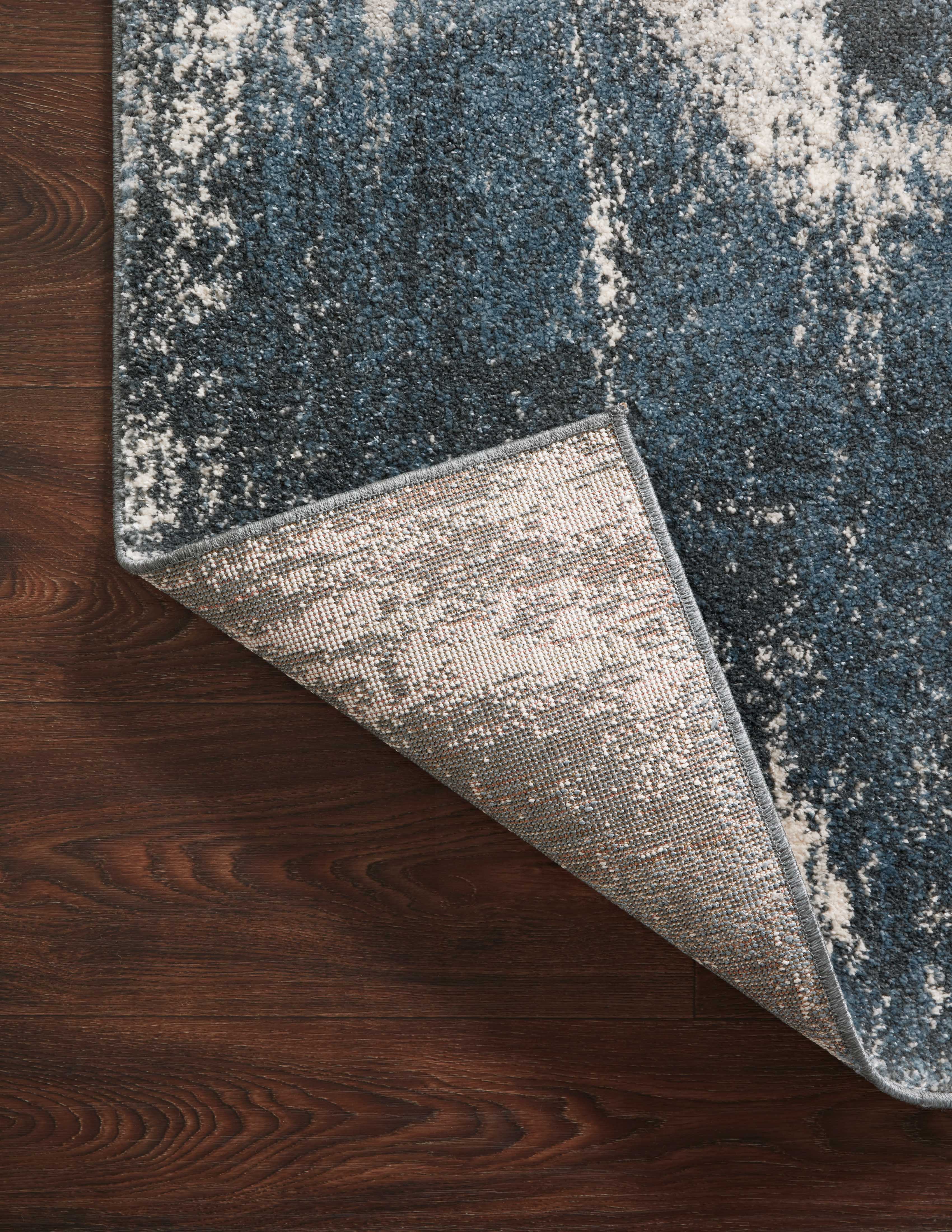 Dressed in deep indigo and refined ivory hues with abstract detail, the Spirit SPI-04 Indigo / Ivory Area Rug is a power-loomed 100% polypropylene area rug that completes any room