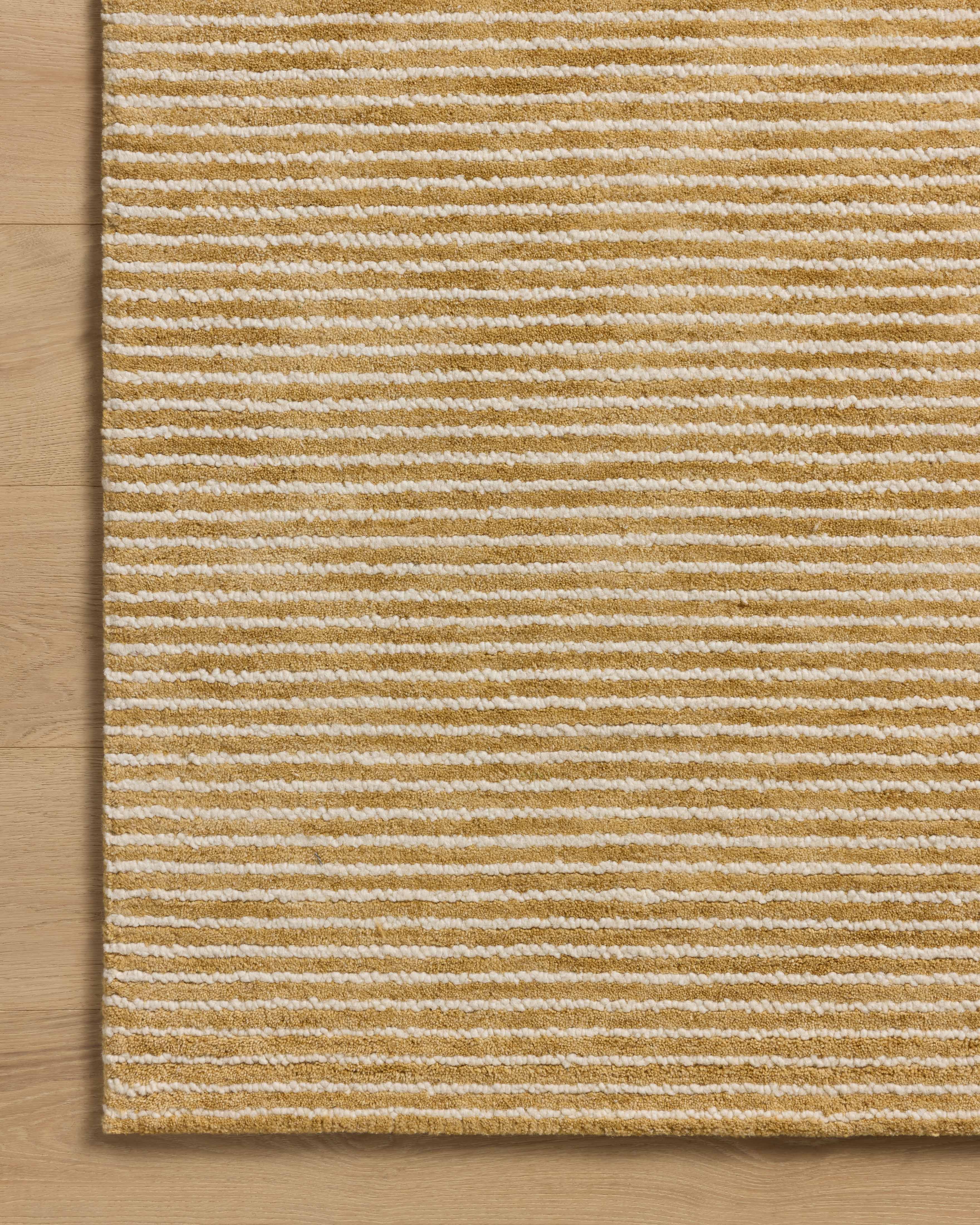 Designed in golden wheat and refined ivory hues, the Sunday SUN-01 Wheat / Ivory Area Rug is a hand-tufted wool area rug that stands out