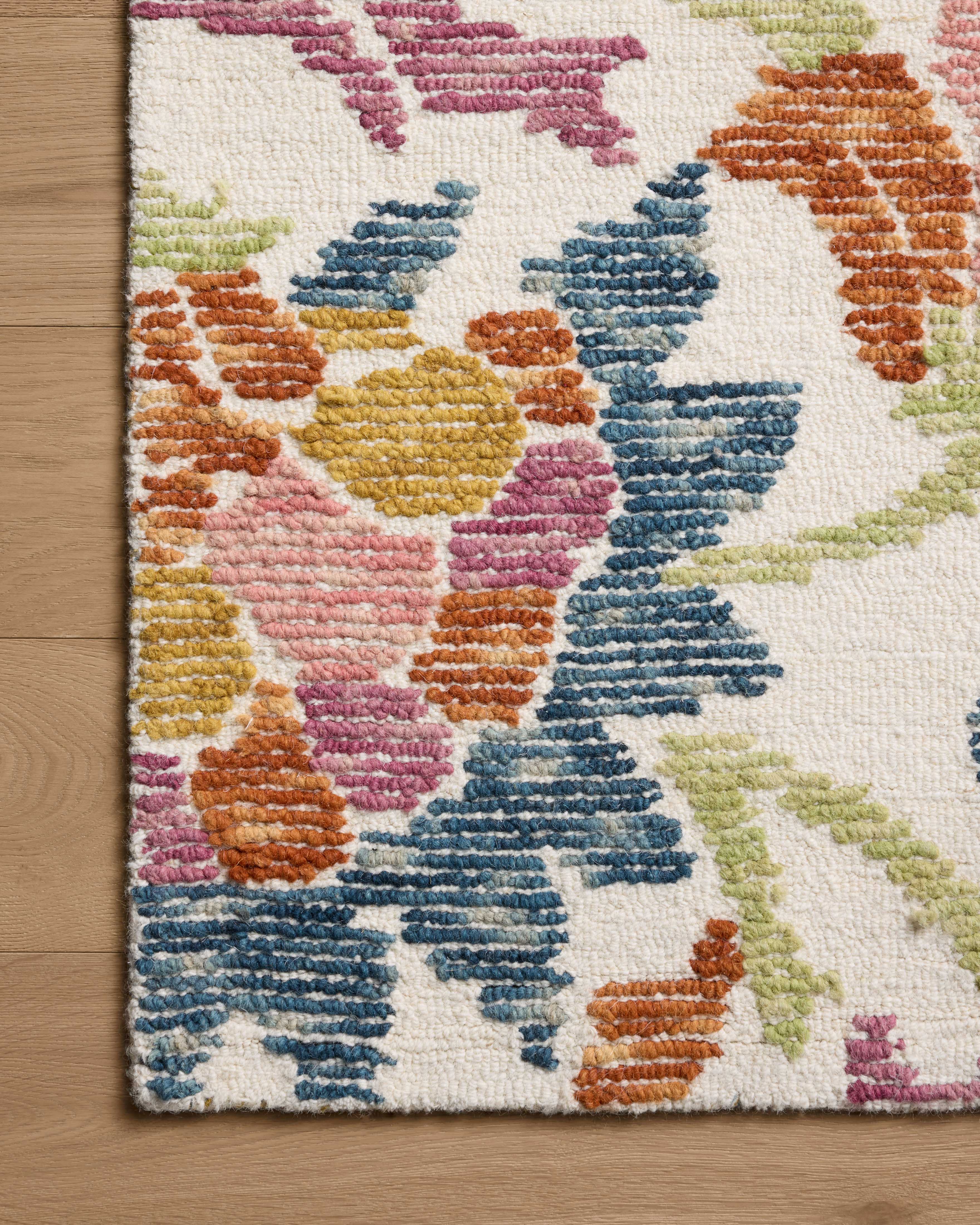 The Tilly TIL-02 Ivory / Multi Area Rug pairs refined ivory and vibrant multi-toned tones and floral and high-low textured patterns in a hand-tufted wool area rug