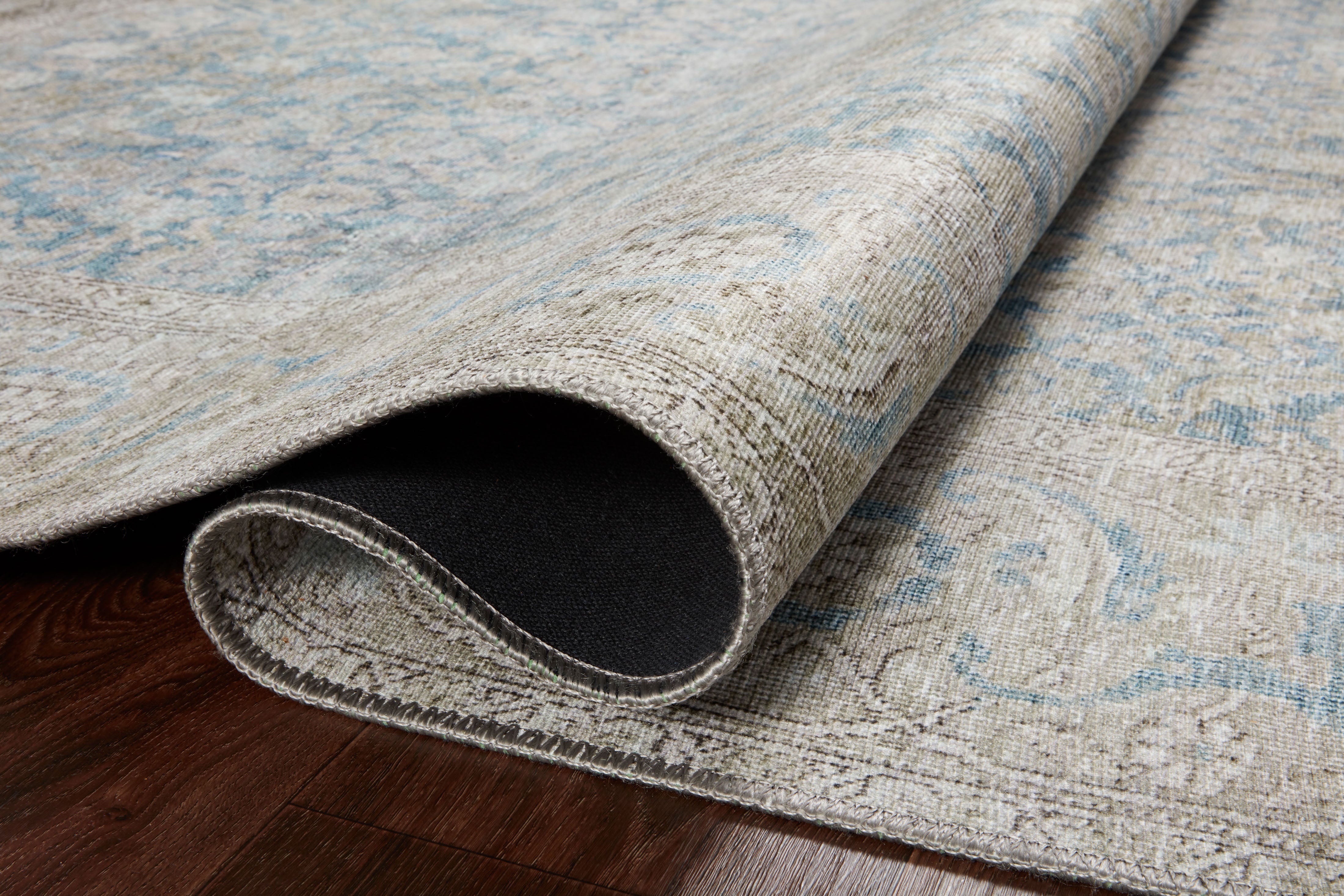 A power-loomed 100% polyester area rug in serene ocean and shimmering silver tones, the Wynter WYN-10 Ocean / Silver Area Rug anchors any room