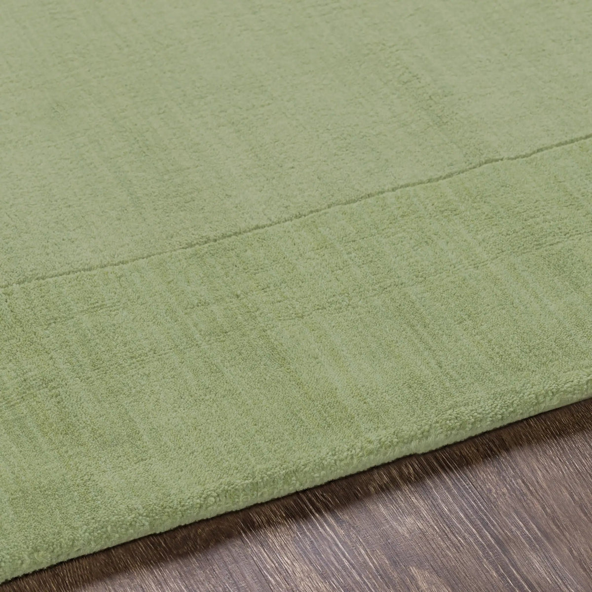 Livabliss Mystique M-310 medium green hand-loomed wool area rug with balanced high and low pile texture resting on dark wood flooring.