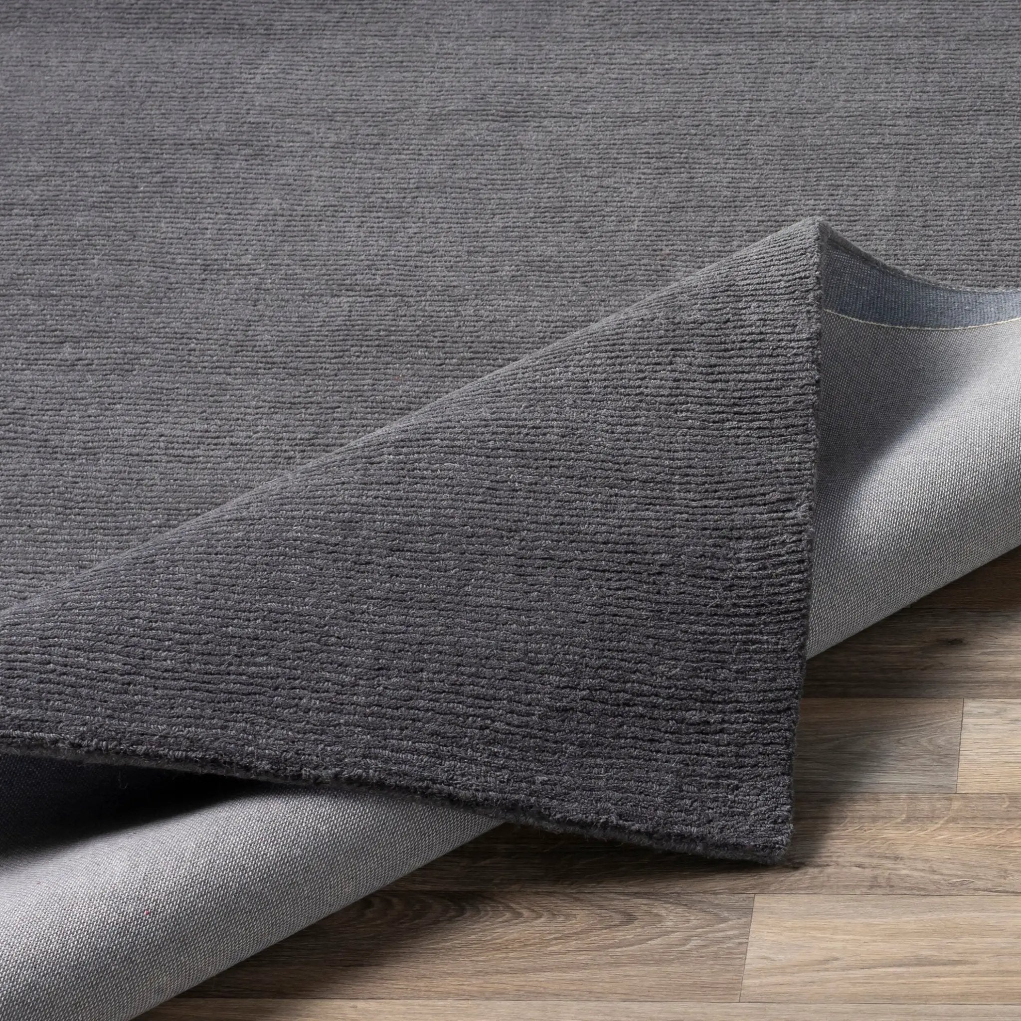 Livabliss Mystique M-341 Charcoal high-low pile wool area rug with hand-loomed texture, displayed on hardwood flooring.