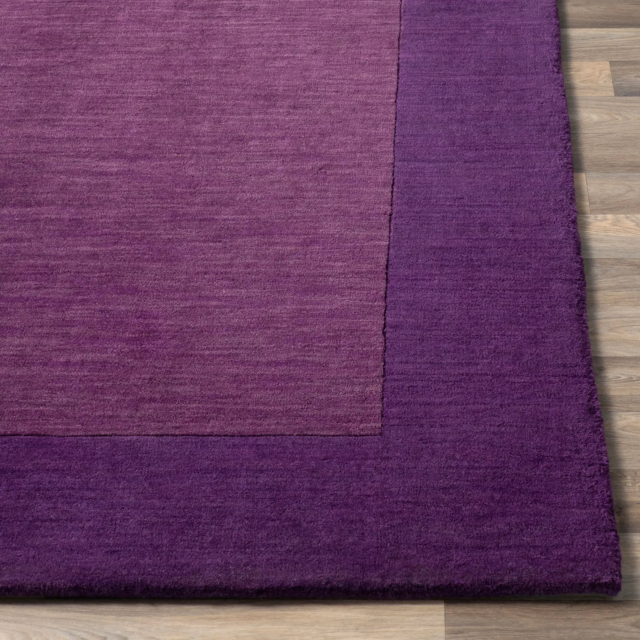 Livabliss Mystique M-349 Purple area rug with hand-loomed wool texture featuring a lighter center field and darker border on wood flooring.