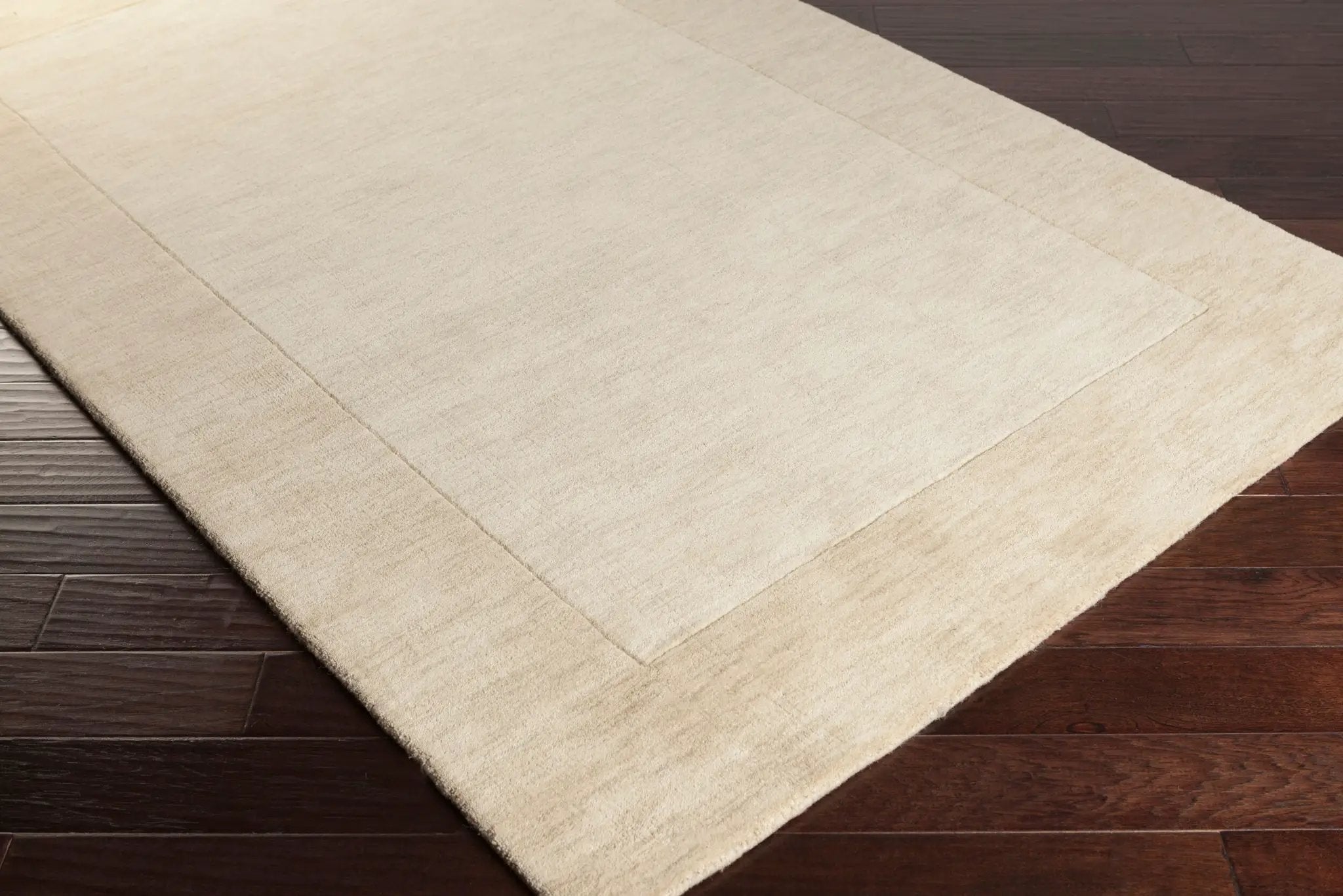 Livabliss Mystique M-5324 Textured wheat tone area rug with high-low pile border on dark hardwood floors. Hand-loomed with 100% wool and neutrals for contemporary spaces.