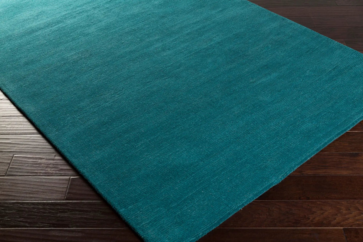 Livabliss Mystique M-5330 Deep teal hand-loomed wool area rug with contemporary high/low texture on dark hardwood flooring.