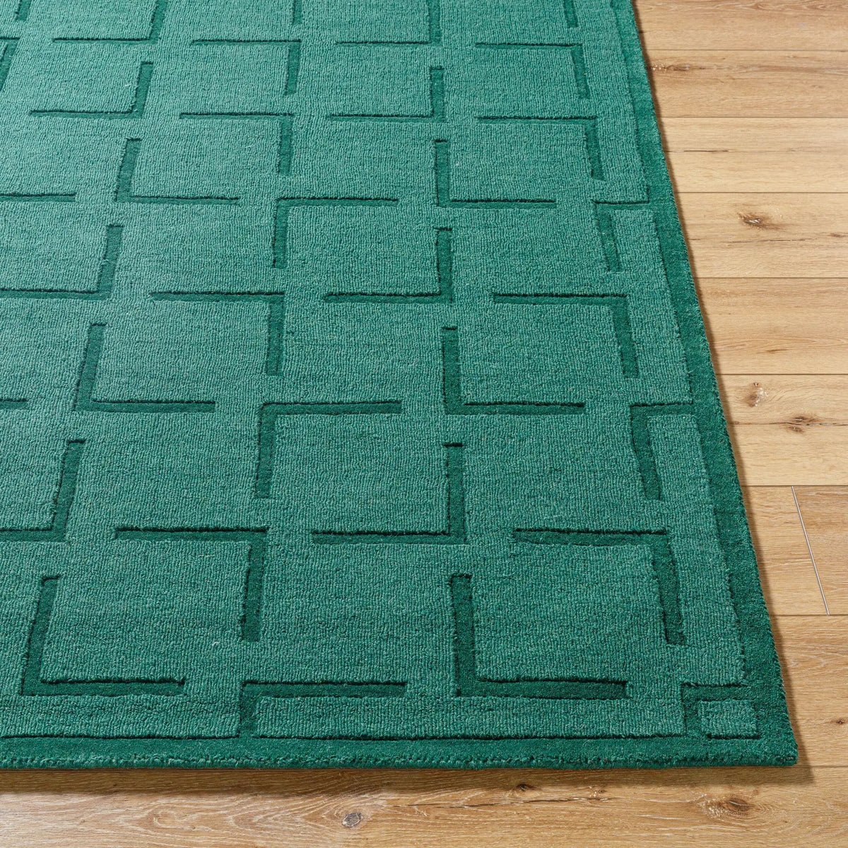 Livabliss Hand Loomed Mystique M-5490 Emerald Green area rug with embossed geometric pattern on natural wool, featuring consistent texture and contemporary design on wood flooring.