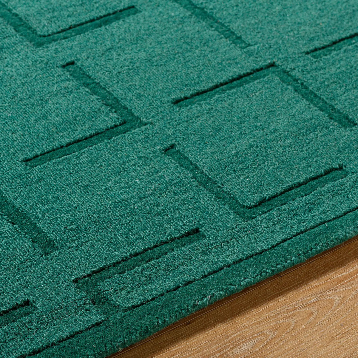 Livabliss Hand Loomed Mystique M-5490 Emerald Green area rug featuring a geometric block pattern and medium pile texture, crafted from natural wool on a hardwood floor.