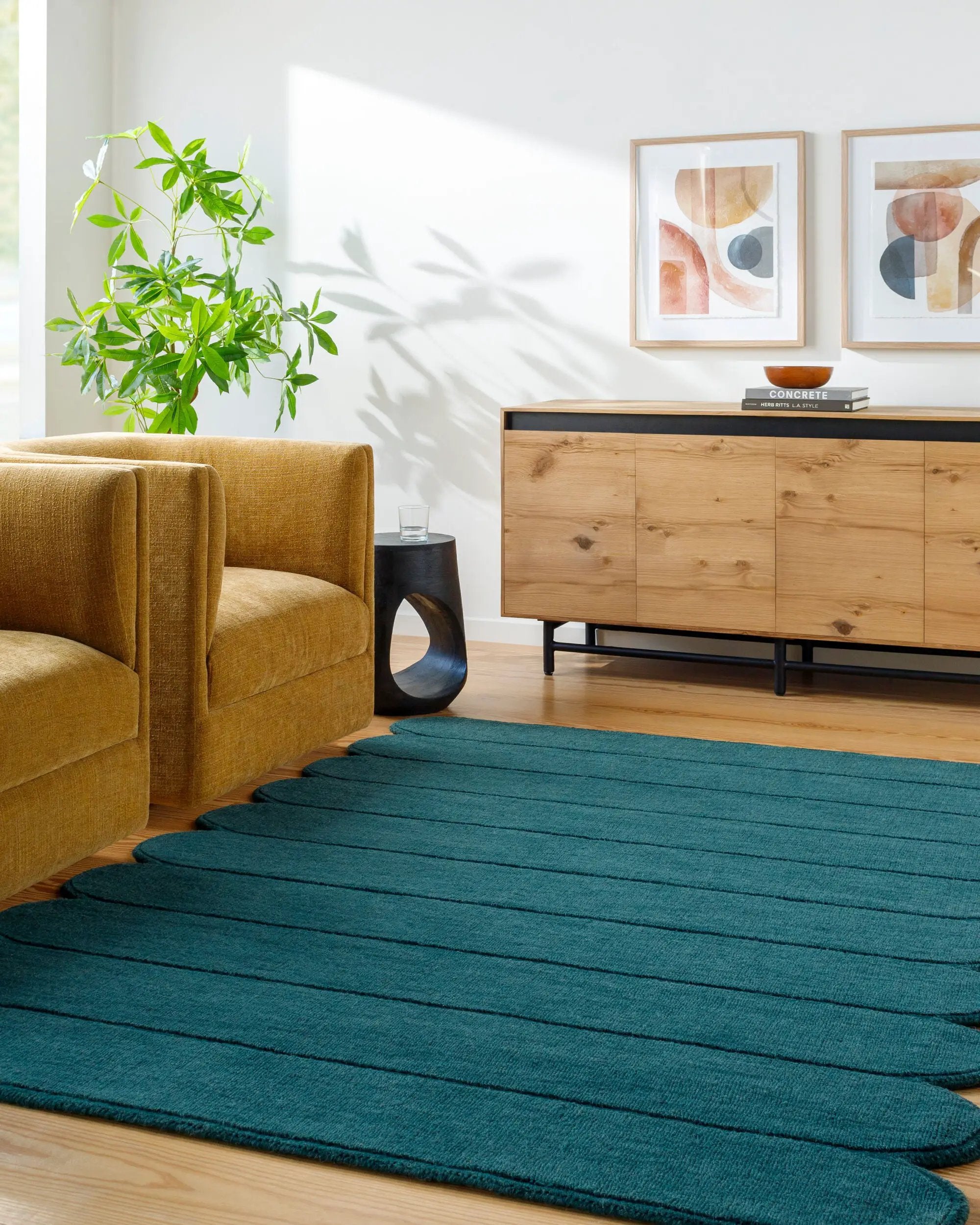 Livabliss Mystique M-5491 Teal hand-loomed wool area rug with distinctive ribbed texture placed on hardwood floors beside a mustard armchair and wooden sideboard.