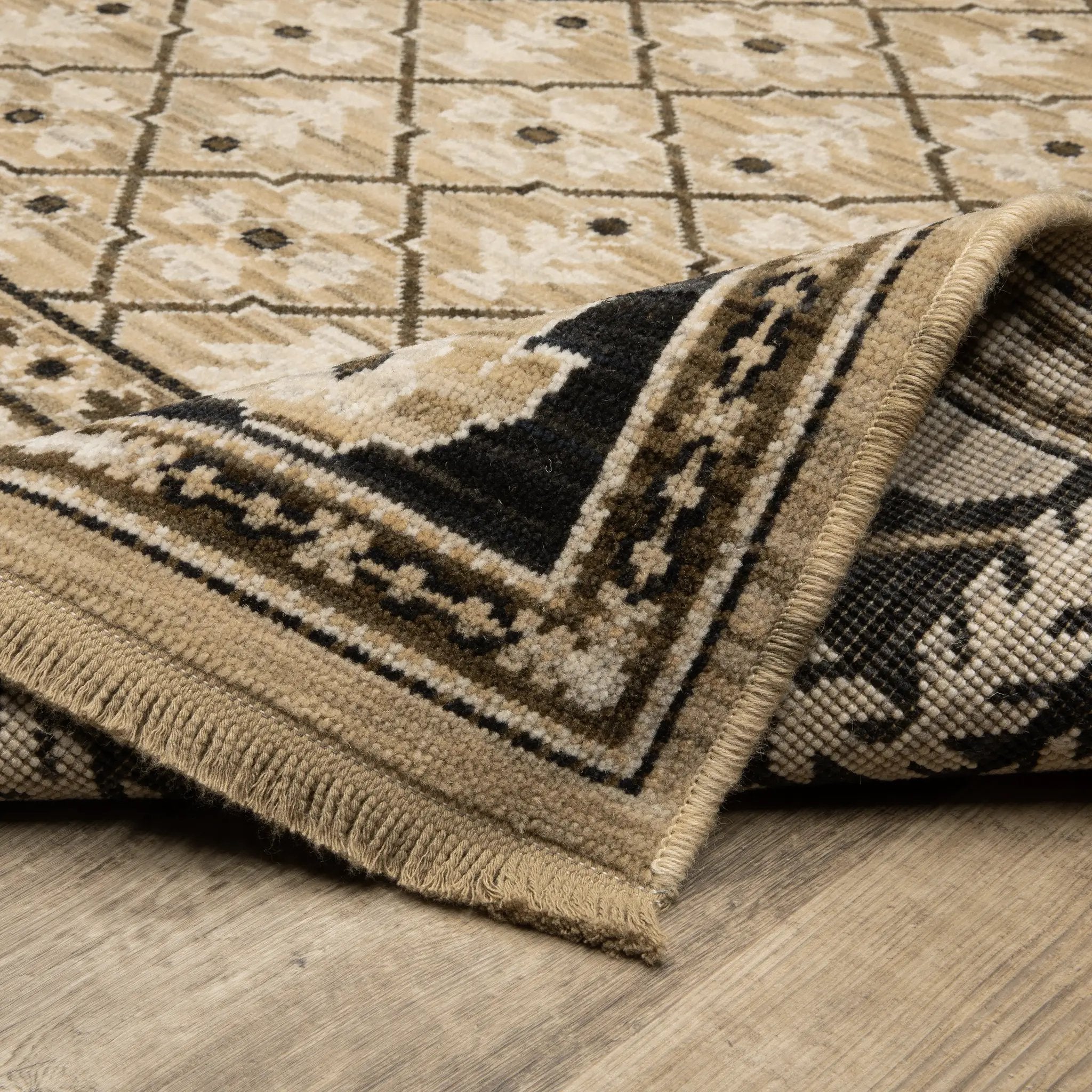 Acacia ACA12 Tan/Charcoal area rug with warm tan ground, charcoal contrast, traditional pattern detail, earthy accents, and cotton fringe.