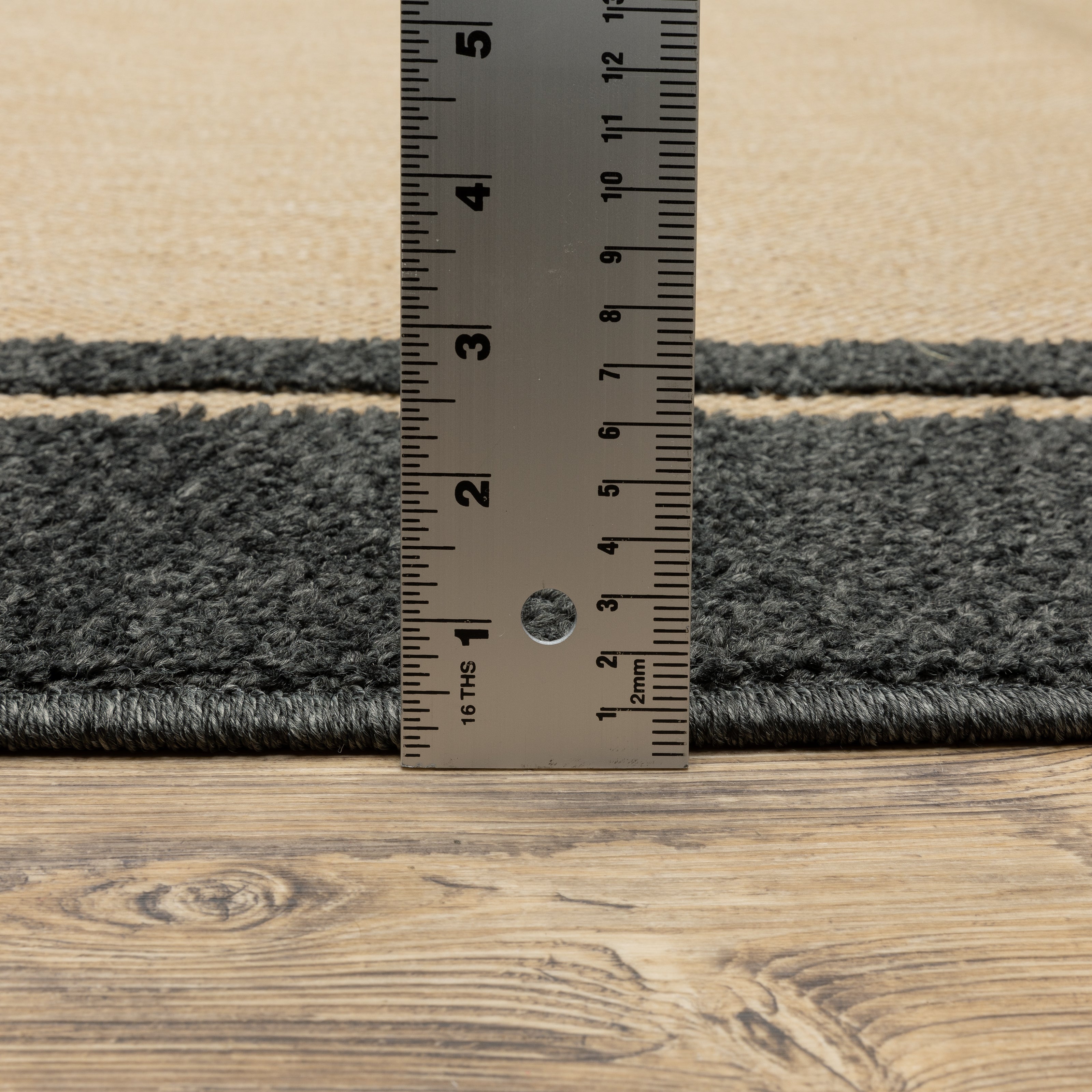 Oriental Weavers Cayman 5594K textured indoor-outdoor rug featuring abstract pattern in sand/ charcoal tones