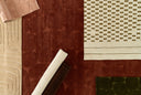 Hand-loomed Canyon area rug with sculpted high/low pile in moss green, rusted red, and warm neutrals, featuring organic, nature-inspired motifs.