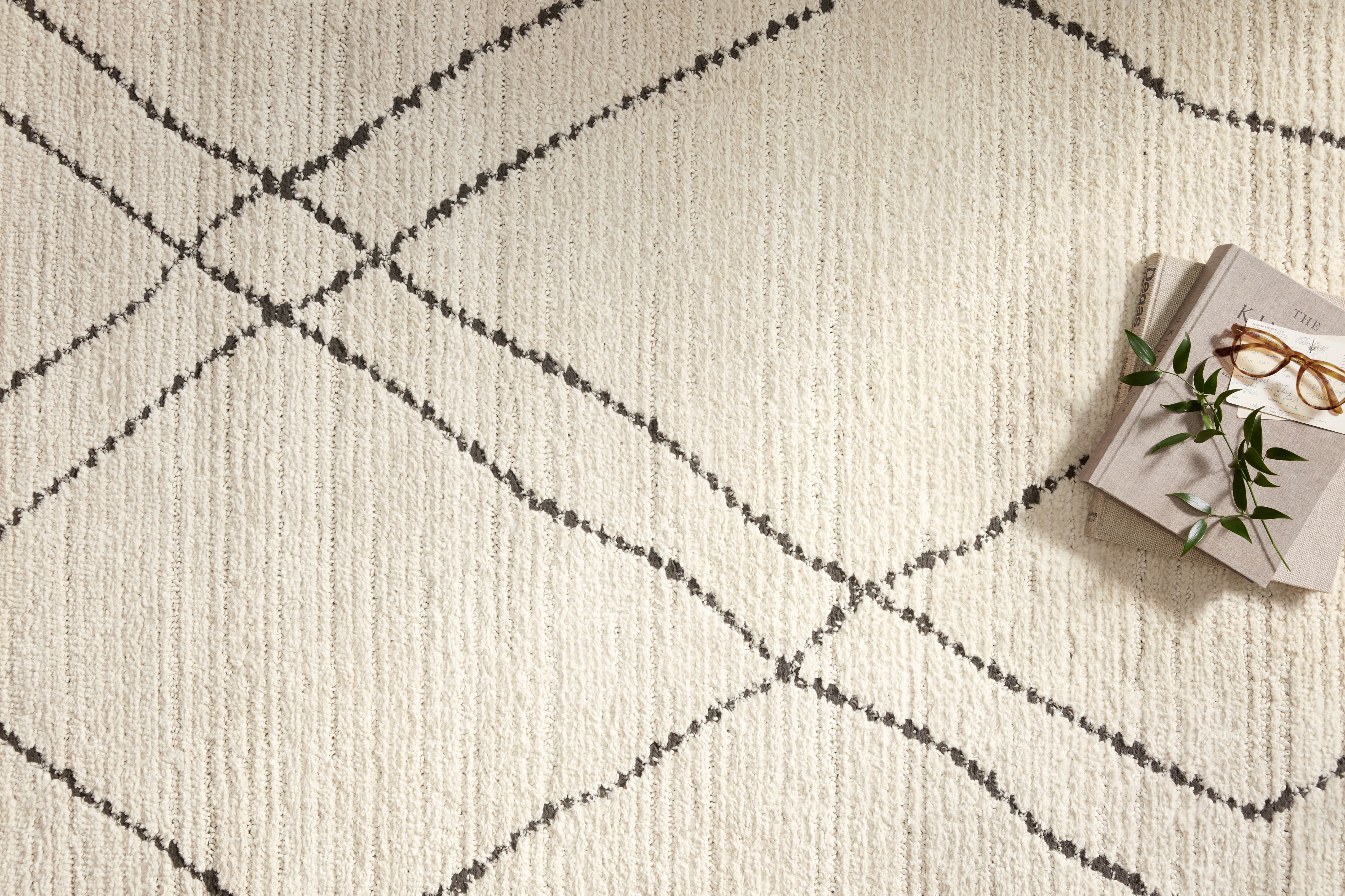 Elegant Loloi Fabian rug with modern Moroccan diamond patterns in two-tone greige and soft black, featuring a plush high-low texture and durable polyester construction.