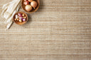 Hand-loomed Loloi Jamie Collection rug in softly variegated abrash colors, made of jute, polyester, and select fibers, displayed in a warm, inviting home setting.