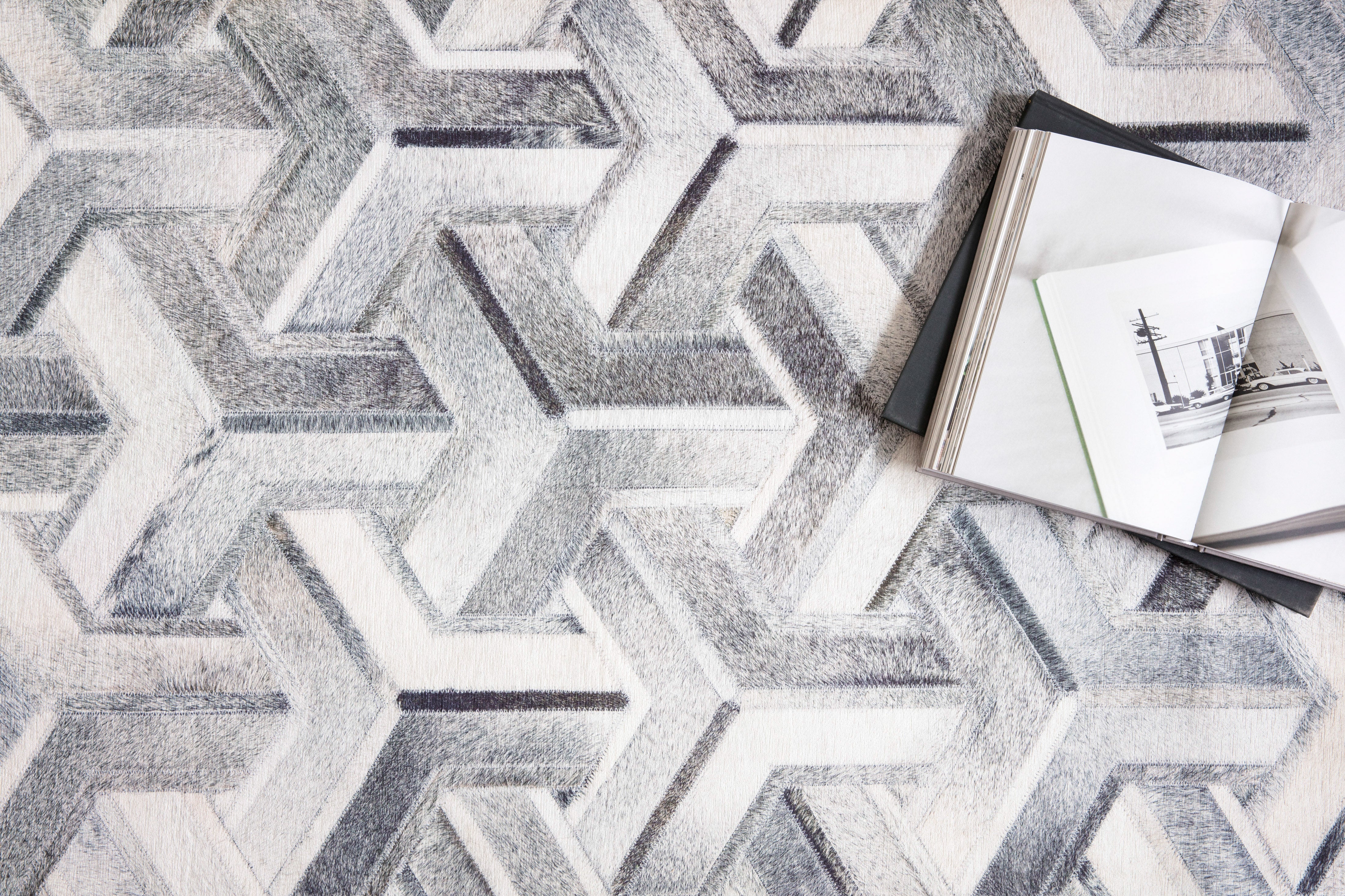 Modern cowhide patchwork rug from the Maddox Collection by Loloi, showcasing a realistic animal hide pattern printed on soft polyester in a contemporary setting.