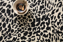 Masai Collection area rug by Loloi—100% wool, modern animal print design in contrasting hues, plush texture, hand-hooked by artisans in India, styled in a contemporary living space.