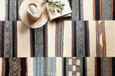 Area rug from the Loloi Mika Collection featuring abstract and tribal patterns, textured yarn, and blanket-stitch edge, suitable for indoor or outdoor spaces.
