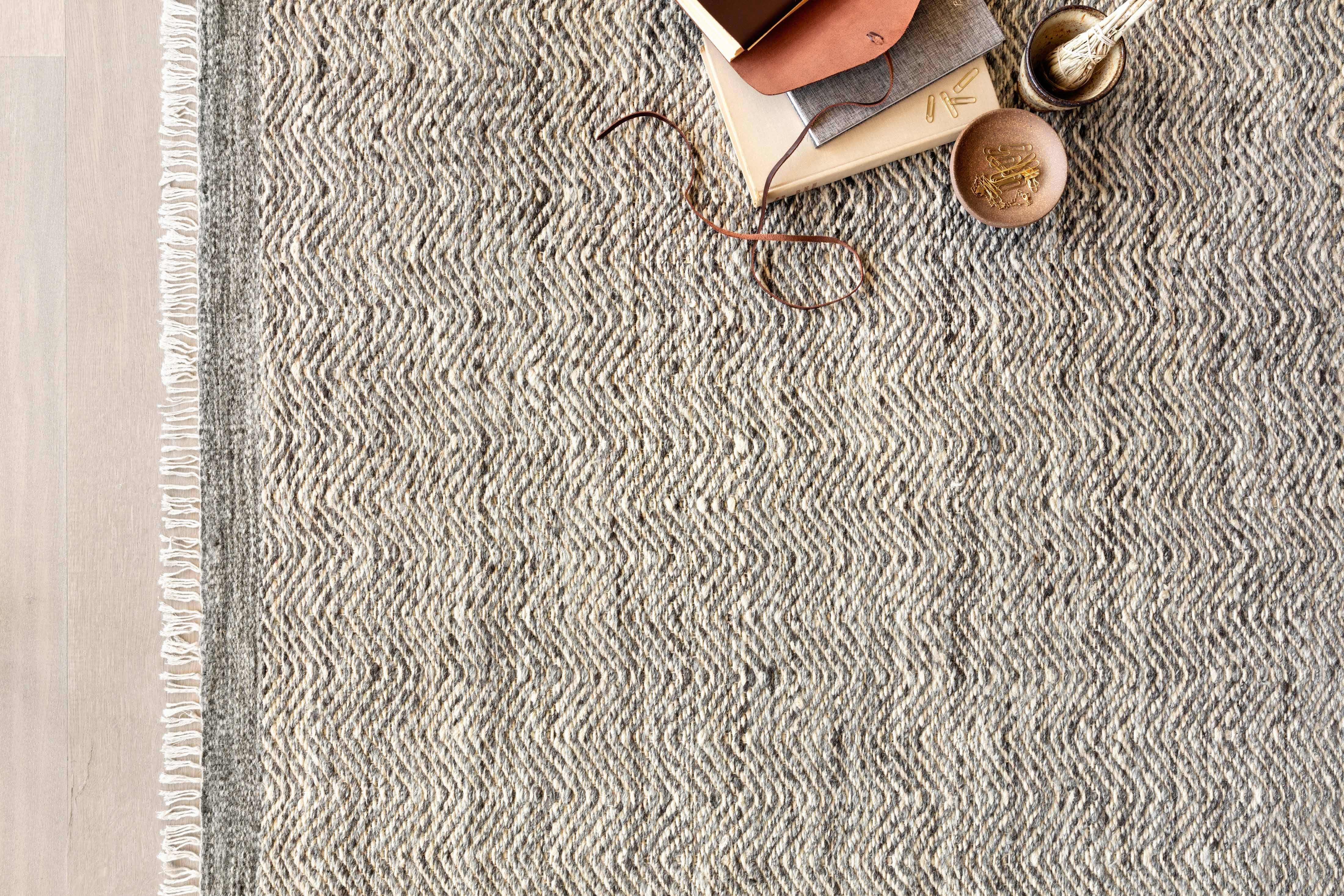 Hand-woven Loloi Omen Collection area rug in India, featuring elegant chevron waves in natural jute, wool, and cotton, GoodWeave certified for ethical craftsmanship.