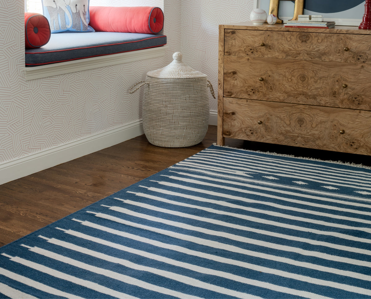 Erin Gates by Momeni Thompson Rug Collection blue striped rug in a cozy room with a window seat, woven basket, and a wooden dresser.