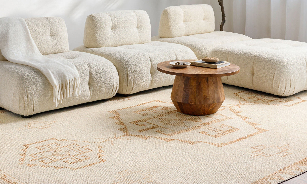 Becki Owens x LIVABLISS Solana area rug in neutral beige with geometric border in a cozy living room.
