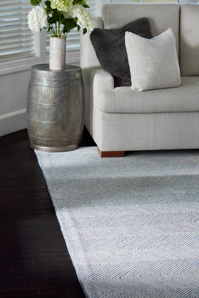 Charles CHR-1 Blue Area Rug with a herringbone zig-zag pattern under a sofa and side table.